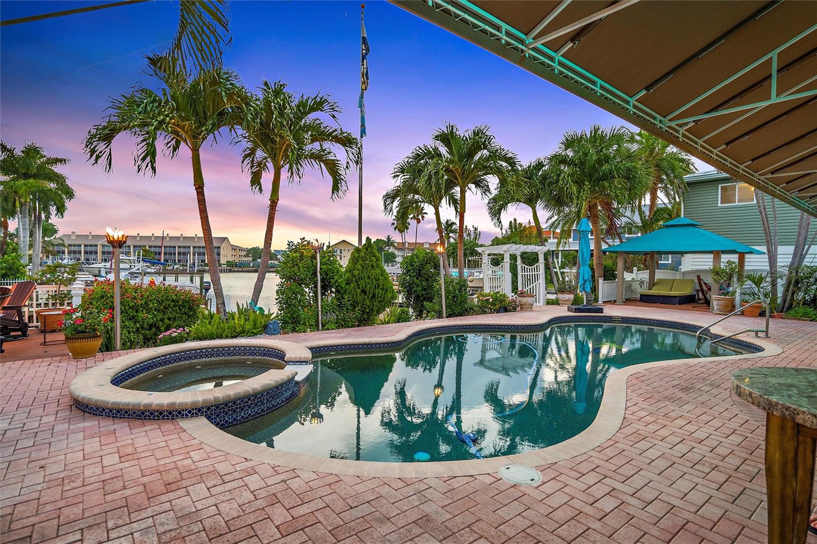 HUGE Price Reduction, Buyer cancelled the contract, his loss will be your opportunity. Seller wants to move on, bring all offers. ~Tropical Oasis~ Live where others vacation. This beautiful waterfront ranch style home can rightly brag about its gorgeous curb appeal, beautiful landscaping, and nightly colorful sunsets overlooking a wide canal in the highly desirable Sands Point section of Tierra Verde! Your soon-to-be new home consists of an open floor plan in the main living and kitchen areas that spreads lots of natural light and glorious water views from 28' floor to ceiling glass on the south facing dining room and entertainment area. There are 3 nicely sized bedrooms (two of which have great water and sunset views through large 6'x7' windows) and two full updated bathrooms. The master bedroom is separate from the other 2 bedrooms for lots of privacy and has an an-suite bathroom with separate tub and updated walk-in shower, double vanity with granite countertop and a nice walk-in closet with a California Closet system. The 2nd and 3rd bedrooms share a full bathroom, which includes a walk-in Steamist Steambath shower!! The kitchen has been recently renovated with all new cabinets, stone countertops, stainless -steel appliances, and a big island for entertaining guests. Marble flooring extends through each room of the home, and both interior and exterior of the house was freshly painted in 2019. The moment you walk outside to the back yard you will feel like you are in a tropical oasis with lush landscaping, including "Thai Gardens "that any lover of Thai food (or aspiring Thai chef) will be eager to utilize. To entertain your guests as they enjoy the relaxing atmosphere there is a saltwater pebble-tec pool and spa, a custom outdoor kitchen with oversized grill, outdoor refrigerator and ice-maker. On the side of the house there is extra storage and a greenhouse to grown your own herbs or plants. The entertainment value is further enhanced by a waters-edge deck with a gas firepit, several gas torches along the garden edge, and a gazebo that will have you sitting outside relaxing and enjoying the gorgeous sunsets. Oh and be prepared to watch the manatees and dolphins swim by your dock! Boat owners will be super thrilled with the easy in/out passageway through the wide canal that provides 10-minute access to the Intracoastal Waterway, The Gulf of Mexico and Tampa Bay. The dock has a 16.000 lbs lift that will keep your large boat safely out of the water (the owner previously kept a 31' SeaRay on it). The wooden dock top boards have been replaced in 2021. The 2-car garage has lots of storage cabinets, two ceiling mounted storage racks and a nice epoxy coated floor. This beautiful one level home located on the quiet part of Sands Point but still very close to the pristine sands of St. Pete Beach , Fort-de-Soto park, downtown St. Petersburg, Tampa International Airport and many restaurants, museums, sporting events, concerts, etc. This is your chance to live in paradise, so don't wait too long to make this YOUR HOME.