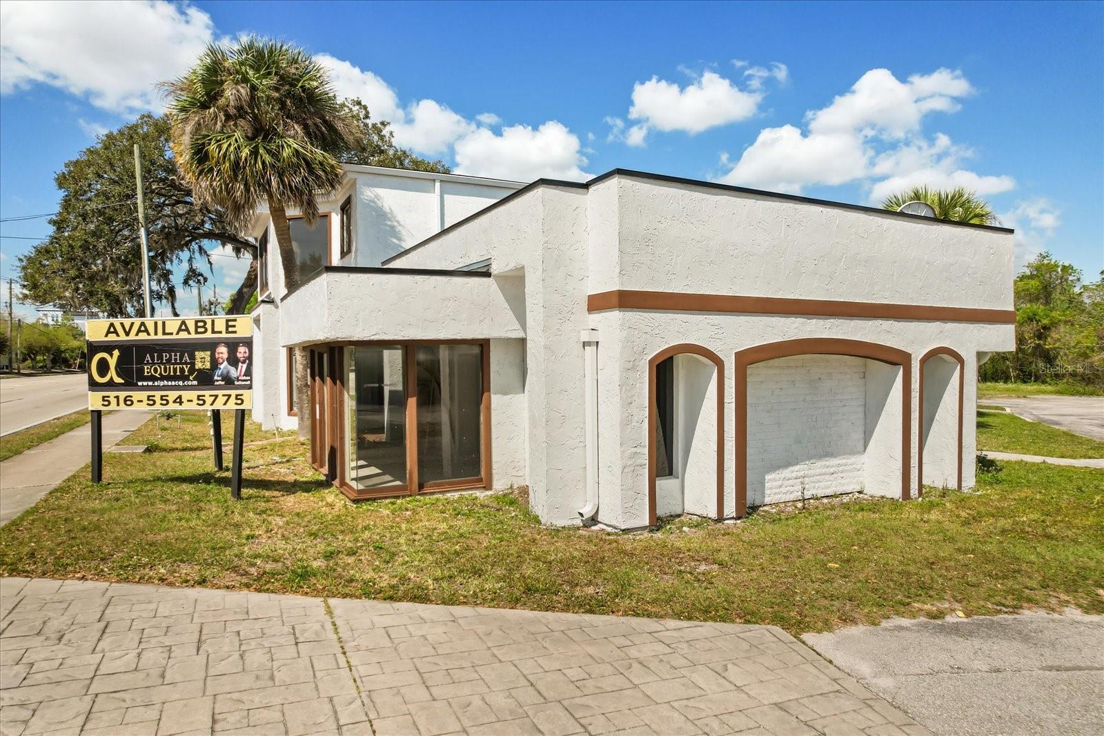 Located at a high-traffic intersection in Longwood, this iconic standalone commercial building offers 4,362 sq ft of versatile showroom, office, or studio space on a 0.53-acre lot. Featuring a distinctive architectural style and over 85 ft of frontage on State Road 434, the site delivers exceptional brand visibility. Step inside to discover a spacious layout flooded with natural light through expansive front windows and a glass-enclosed sunroom ideal for displays or a waiting area. The flexible interior includes multiple private offices, reception or common areas, two restrooms, and a break room/kitchenette—all enhanced by a thoughtful blend of tile and carpet flooring with decorative custom finishes. Additional highlights include ample on-site parking, dual entry points, signage opportunities, and skylights, with convenient access via public transportation and 24-hour accessibility. Whether it’s for a boutique studio, wellness clinic, retail storefront, or professional office, this property combines character, convenience, and high visibility in one package. Zoning: Commercial. Available for lease immediately.
