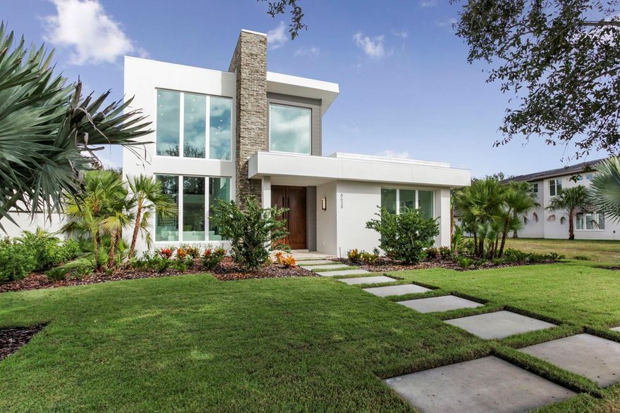 This modern, courtyard home is located behind the gates of Lake Nona Golf & Country Club and offers proximity to member amenities and the community’s lake access. With sleek architectural design, this residence features an open yet functional floor plan with fluid indoor-outdoor entertaining. An abundance of oversized windows, volume ceilings and white porcelain tile floors enhance the spaciousness of the interior. Separate main living areas, including a great room with living and dining spaces and a family room, offer private yet stylish areas for hosting friends and family. The chef’s kitchen comes dressed in white quartz countertops, an elegant waterfall island, luxury appliances by Thermador and soft close, flat panel cabinets. Two sets of sliding glass doors from the kitchen and the dining room allow for free-flowing access onto the expansive covered lanai. Unwind in the upstairs owner’s suite with two walk-in closets, a spa-like bathroom and a balcony overlooking the resort-inspired courtyard. Step outside to relax and enjoy the pool or sunbathe in the privacy of your own backyard on the travertine pool deck. Additional features include an office with sliders to the pool, pool bath with a sauna and a four-car garage.