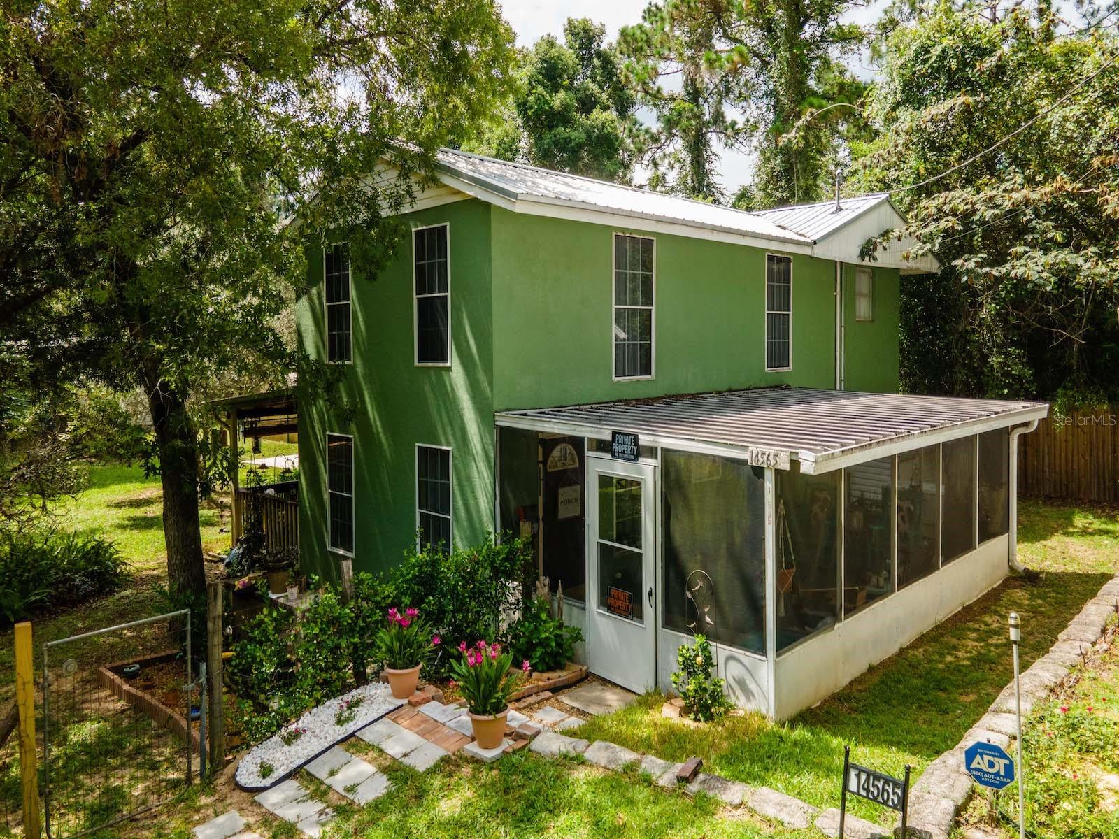 Welcome to this charming two-story home located in the peaceful and serene Ocala National Forest and NE Marion County. Situated on a spacious .61-acre lot, this property boasts 240 feet of frontage and 100 feet of depth. With 2,764 square feet of living space, this home offers ample room for comfort and privacy. The home features three bedrooms located upstairs and three full bathrooms, including a handicap-accessible bathroom on the main level. As you arrive, you are greeted by an oversized 30'x30' two-car garage, providing plenty of space for vehicles and additional storage. This garage leads to an entrance and a 12'x22' screened room that opens up to the front door, offering a lovely space to enjoy the outdoors. Inside, the spacious 28'x16' living room is filled with natural light and boasts tiled floors. The main bedroom is generously sized at 15'4"x26' and features beautiful Southern Pine floors and ceilings, along with a full bathroom. The 2nd guest bedroom is 10'8"x14'10" and features wood floors and ceilings, creating a warm and inviting atmosphere. The 3rd bedroom is 11'3"x14'11" and includes a separate sitting room leading to the bedroom. Upstairs, the second bathroom offers a tiled shower and floors. The downstairs bathroom is 10'x8" x 14'x10" with a tiled walk-in shower and floors for a clean, modern look. The kitchen includes painted wood cabinets, Formica countertops, center island and ample counter space, along with a gas range, refrigerator, and dishwasher. There is dining area located just off the kitchen Bedroom 4(14'x10" x 15'x3") is downstairs and currently being used for storage or use for office/den. The rear covered porch offers a relaxing spot to overlook the large side yard, which includes several mature trees with fish cleaning and garden potting area as well. Additionally, there are 2 storage shed and a 20'x25' metal building with a concrete floor, roll-up door, and side entry door, perfect for use as a workshop or additional storage. The home includes a Generac whole-house generator for peace of mind, especially during power outages. The metal roof was replaced in 2019, and the exterior was painted approximately five years ago. Two safes are included for added security and washer and dryer are included. The living room, kitchen, and bathroom have all been updated with new electric wiring. The stair can be included in the sale. This property is located just 20 minutes from Fort McCoy, where you'll find essential amenities such as a grocery store, doctor's office, pharmacy, hardware store, gas station. A short drive will take you to Silver Springs, offering Walmart, Lowes, Bealls, Outback Steakhouse, and more shopping and dining options. Ocala is just another 10-minute drive, with vibrant nightlife and plenty of entertainment and restaurant choices. Gainesville, home to the Florida Gators, is a mere 50 minutes away. For outdoor enthusiasts, this location is ideal, with easy access to the Ocklawaha River, Ocala National Forest, and several natural springs, including Salt Springs, Silver Glen Springs, and Juniper Springs. Enjoy hiking, canoeing, kayaking, horseback riding, or exploring off-road vehicle trails in the vast Ocala National Forest, which spans over 380,000 acres and offers 125 miles of trails, including a 14-mile motorcycle-only trail. This one-of-a-kind property offers a fantastic location and a comfortable home, ready for new owners to enjoy. Don’t miss out on this rare opportunity!