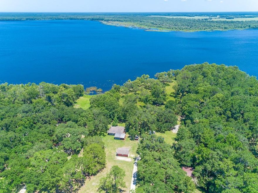 PRICE REDUCTION 9/27/2019 TO $434,900.00!! THIS HOME COMES WITH A WARRANTY!! Quite possibly one of the most unique properties offered for sale in the greater NSB area in a very long time. 9+ acres on the western shore of Lake Ashby with a completely updated and modernized doll house to go with it. Quiet, private, roomy, and a nearby CREEK that babbles right on into Lake Ashby. There aren't many places with this kind of natural beauty any more, anywhere, unless you go to a public preserve or park. Wildlife is everywhere. Deer, turkey, waterbirds, and some of most beautiful mature oak trees in the county. While the house may be conservative in size, it is been gone through from stem to stern and is as comfortable as can be. Lifetime vinyl plank floors throughout, new appliances (washer and dryer not included), high end oscillating ceiling fans with lights and remotes, wind rated thermal pane windows, and bathrooms have all been completely done and professionally appointed. In a country setting like this, only your imagination limits the possibilities of how you can enjoy the natural beauty of this waterfront jewel. There are 3 out buildings here also: a huge quonset style garage with room for cars, trucks, and tractors, a very spacious work shop, and a shed for lawn equipment. There is also a pump house that houses the private well and water treatment system for the residence. If your thing is being immersed in the natural world and leaving the mahem behind, this is a must see. Once here, you won't want to leave. Seller Disclosure and Survey attached to this listing.