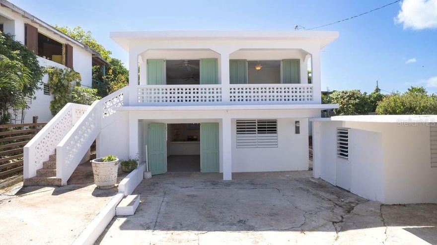 Tucked away in the Bravos de Boston neighborhood, this cozy two-story home offers ocean views, proximity to the city’s conveniences, and flexibility. Traditional touches, such as mint green wooden barn doors, add character to the property. Less than a five minute walk from the ferry, and less than a fifteen minute walk to the shops and restaurants in Isabel II, as well as Seaglass and La Chata beaches, this location is perfect for those who want easy access to everything. The home features two private, self-contained apartments, making it ideal for extended family, guests, or as a potential rental opportunity.

The upstairs unit is a spacious two-bedroom, one-bathroom apartment. It blends traditional design with contemporary living, with classic ceramic tiles throughout the space. The airy, sunlit open-concept living area flows seamlessly into the kitchen, which is equipped with built-in cement cabinets and open shelving. Both bedrooms offer ocean views, while the front bedroom opens directly onto a private balcony—perfect for enjoying the sea breeze. This unit also offers two entrances—one from the living room and one from the kitchen, providing added flexibility and easy access.

Downstairs, you’ll find a second unit that mirrors the charm and open-concept layout of the upper unit. The kitchen, also featuring built-in cement cabinets and open shelving is complemented by a pantry for additional storage. The two bedrooms look out onto the garden, and the space flows effortlessly, making it perfect for day-to-day living.

The home’s exterior is just as inviting as the interior. A fully fenced-in property provides privacy, while the green space adjacent to the building is ready for you to cultivate a garden, plant palm trees and florals, or even build a plunge pool—creating your own private oasis. The outdoor laundry room, complete with an outdoor shower, adds convenience, while the carport offers shelter for one vehicle, keeping your ride protected year-round.

With its blend of traditional charm and modern convenience, this home offers a unique opportunity—whether you're looking for a property with rental potential or simply seeking a coastal retreat.