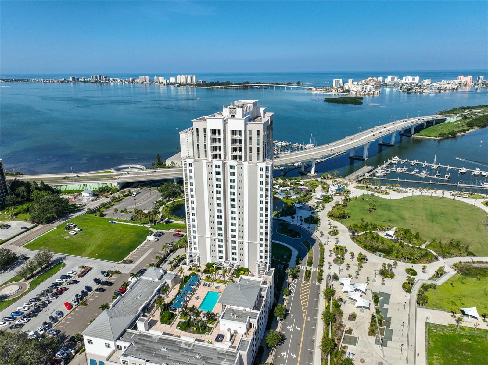 Enjoy stunning water and city views from this beautifully maintained 7th-floor condo at Water's Edge in downtown Clearwater. This spacious residence features an open living and dining layout with engineered hardwood floors and sliding glass doors leading from both the living area and primary suite to a private balcony overlooking the skyline. The kitchen is designed for both style and function with wood cabinetry, granite countertops, tile backsplash, stainless steel appliances, and a large breakfast bar. A flexible den/office/bonus space adds versatility to the floor plan. The primary suite offers direct balcony access, a custom bath with dual sinks, and a large walk-in shower. The guest bedroom also enjoys water views and has an adjacent full bath and a laundry room with a stacked washer/dryer. Brand New AC replaced in January 2025. This unit also has TWO assigned garage parking spaces and one storage space. Resort-style amenities elevate everyday living at Water's Edge. Residents enjoy a heated pool and spa with cabanas, outdoor grilling stations, and a cozy fireplace lounge overlooking the marina and Coachman Park. Indoors, you'll find a state-of-the-art fitness center with a sauna, a beautifully redecorated club, and social rooms with a catering kitchen and billiards, plus conference and event spaces ideal for entertaining. A 24/7 concierge provides security and convenience. Located in the heart of downtown Clearwater, you'll be just steps from the marina, Capitol Theatre, library, shopping, dining, and entertainment. and only minutes over the bridge to Clearwater Beach. An easy commute to Tampa International and Clearwater Airports. Call today for your private showing!