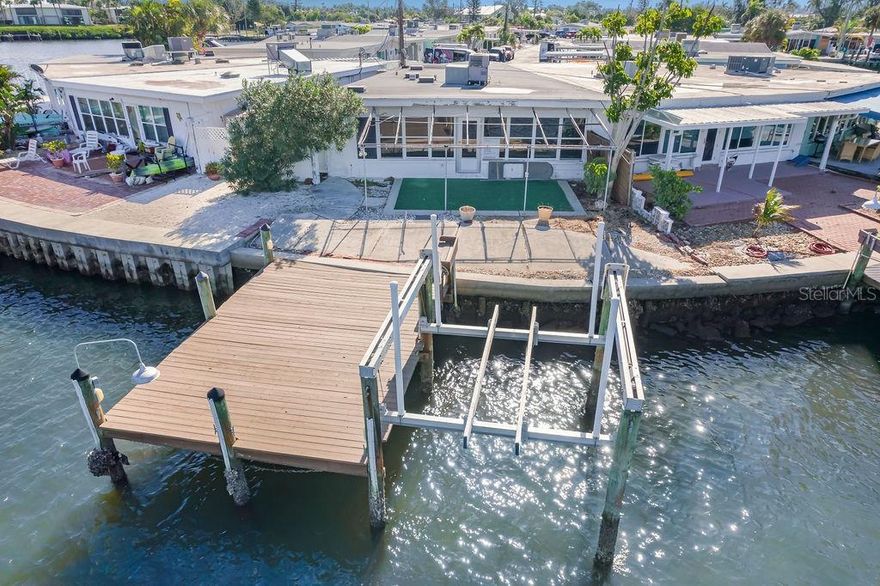 Big water dockage and weekly rentals at an unbeatable price! This 2BD/2BA concrete block villa is a boater's dream, offering an 8000 lb lift, 42 ft seawall, 22x15 ft dock, and additional wet slip. Enjoy direct access to Watson's Bayou, the Intracoastal Waterway, Tampa Bay, and the Gulf of Mexico. Inside, you’ll find an open floor plan with a central kitchen, spacious living area, 2 master suites, and interior laundry. A grandfathered-in awning and carport provide extra outdoor space. Located in Seaside Gardens, with no HOA restrictions, and close to amenities like a boat ramp, tennis, pickleball, and more. Solid construction, prime dockage, and endless potential—don’t miss out!