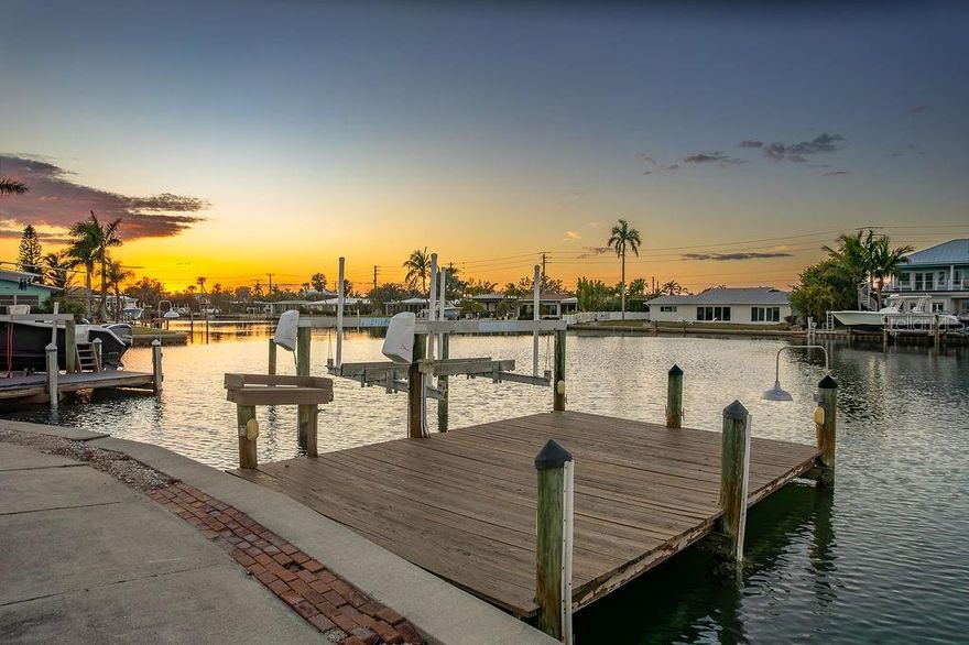 Big water dockage and weekly rentals at an unbeatable price! This 2BD/2BA concrete block villa is a boater's dream, offering an 8000 lb lift, 42 ft seawall, 22x15 ft dock, and additional wet slip. Enjoy direct access to Watson's Bayou, the Intracoastal Waterway, Tampa Bay, and the Gulf of Mexico. Inside, you’ll find an open floor plan with a central kitchen, spacious living area, 2 master suites, and interior laundry. A grandfathered-in awning and carport provide extra outdoor space. Located in Seaside Gardens, with no HOA restrictions, and close to amenities like a boat ramp, tennis, pickleball, and more. Solid construction, prime dockage, and endless potential—don’t miss out!