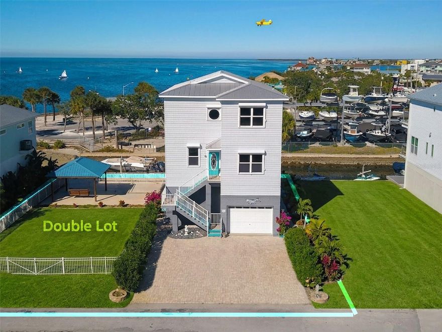 Double lot, elevator and boat lift! This magnificent 4 bedroom, 3.5 bathroom home spans 2,760 sq ft and offers direct Gulf access. Upon entering, you are greeted by beautiful wood flooring, a guest bedroom and/or office, guest bathroom, elevator, and a semi-open concept layout. The kitchen flows seamlessly into the dining and living areas, which are brightly lit by the full-width balcony running along the entire rear of the home. The kitchen boasts new, never used appliances and quartz countertops, equipped with a walk-in pantry of considerable size providing ample storage. Enjoy easy access to all three floors with a recently updated hydraulic elevator, still under warranty. The third floor also boasts a full-width balcony spanning the entire rear of the residence and hosts two spacious secondary bedrooms and a guest bathroom alongside the Primary Suite. Where you can enjoy your private bathroom, breathtaking sunset views and incredible stargazing directly from the comfort of your bed. Enjoy peace of mind and lower energy costs thanks to practical features like electric hurricane shutters, UV energy-efficient window tint, and a robust, recently inspected 2005 metal roof (rated for 50 years). This property also boasts a private fixed wooden dock situated along the seawall and an additional parcel with a boat lift, seawall, fixed gazebo on slab structure and enough room to keep any toys you may have. Additionally, it features a spacious four-car garage which conveniently houses a half bathroom. Located just moments from Hudson Beach's incredible dining spots; Sam's Beach Bar, Ollie's on the Beach, and the famous Hudson Beach Ice Cream Parlor, this is coastal Florida living at its finest.