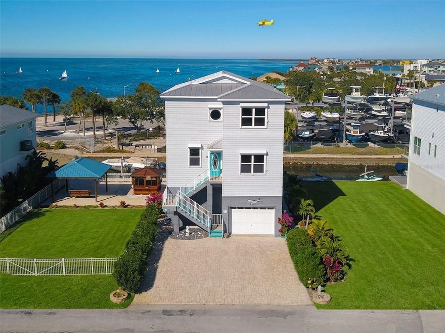 One or more photo(s) has been virtually staged. Double lot and boat lift! Discover the epitome of coastal living at 6249 Lonnie Lee Ln. This magnificent 4 bedroom, 3.5 bathroom home spans 2,760 sq ft and offers direct Gulf access. Upon entering, you are greeted by beautiful wood flooring, a guest bedroom and/or office, guest bathroom, elevator, and a semi-open concept layout. The kitchen flows seamlessly into the dining and living areas, which are brightly lit by the full-width balcony running along the entire rear of the house. The kitchen boasts new, never used appliances and quartz countertops, equipped with a walk-in pantry of considerable size providing ample storage. Enjoy easy access to all three floors with a recently updated hydraulic elevator, still under warranty. The third floor also boasts a full-width balcony spanning the entire rear of the residence and hosts two spacious secondary bedrooms and a guest bathroom alongside the Primary Suite. Where you can enjoy your private bathroom, breathtaking sunset views and incredible stargazing directly from the comfort of your bed. Enjoy peace of mind and lower energy costs thanks to practical features like electric hurricane shutters, UV energy-efficient window tint, and a robust, recently inspected 2005 metal roof (rated for 50 years). This property also boasts a private fixed wooden dock situated along the seawall and an additional parcel with a boat lift, seawall, fixed gazebo on slab structure and enough room to keep any toys you may have. Additionally, it features a spacious four-car garage which conveniently houses a half bathroom. Located just moments from Hudson Beach's incredible dining spots; Sam's Beach Bar, Ollie's on the Beach, and the famous Hudson Beach Ice Cream Parlor, this is coastal Florida living at its finest.