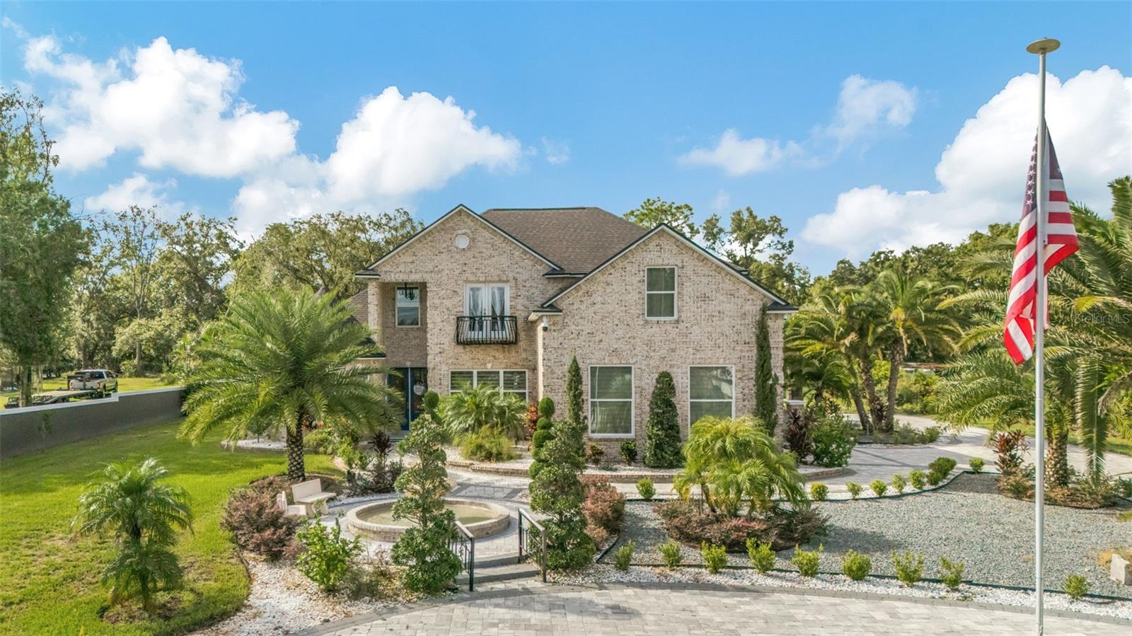 Nestled between Tampa and Orlando, this stunning contemporary home offers the perfect blend of sophistication, comfort, and entertainment. Situated on over an acre of beautifully manicured grounds, this property is more than just a house—it’s a private retreat designed for living, entertaining, and creating unforgettable memories. From the moment you arrive, you’ll be welcomed by a paved circular driveway, meticulously landscaped gardens, and a grand water fountain that sets the tone for the elegance inside. Vaulted ceilings and abundant natural light create an open, airy ambiance, while crown molding throughout adds a refined touch of craftsmanship. A stunning staircase with tempered glass makes a bold architectural statement. The home has an owners retreat and a spa like bathroom on the first floor. Upstairs you will find three additional spacious bedrooms, a full bathroom, and a bonus room providing ample space for family and guests. The second floor also has an office which includes a private balcony that overlooks the lush garden and fountain, making it an inspiring space for work or relaxation. Designed for entertainment and leisure, the backyard offers endless possibilities with an expansive paved patio for gatherings, a private soccer field, and a beach volleyball court. You’ll also find a separate fire pit patio for those cozy evenings under the stars.
This property isn’t just a place to live—it’s a lifestyle investment. With its modern design, functional layout, and resort-style amenities, it’s ideal for families, professionals, and anyone who loves to entertain.
https://tampa-home-photos.aryeo.com/videos/019919ef-1a64-7375-b9c6-8cb74f279f8f?v=383