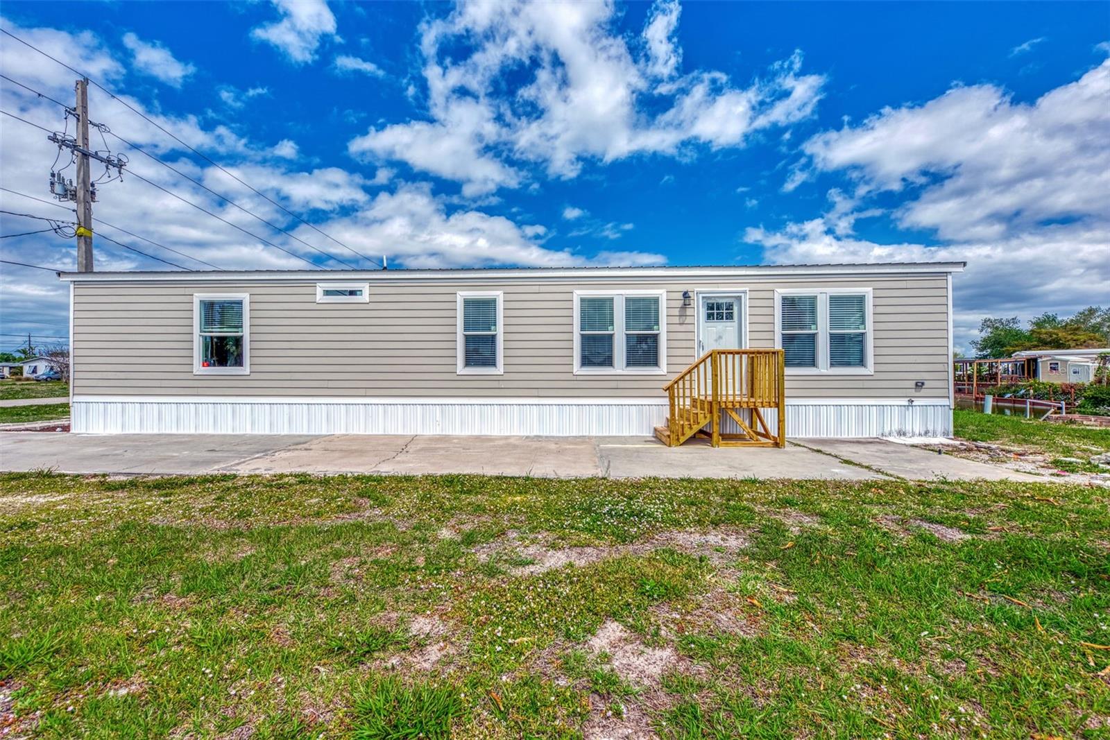 BACK ON THE MARKET WITH A $50,000 price adjustment for this waterfront home. This home comes Furnished and is located on the Redfish Waterway. This Manufactured home has 960 square Ft. and was built in2022. Crafted by Winston Home builders nestled in the coveted Manatee Cove of Englewood/Holiday Estates 2nd addition. This home was built for wind zone III (110) MPS and is securely anchored accordingly providing peace of mind for homeowners. The community is a 55+ community and the pristine home offers a fresh start in a desirable location. Are you an avid fisherman? The waterway behind the home has many types of fish and plenty of available fish for you to catch. If you are looking for a winter home this is the prefect investment or if you are out looking for a annual home to enjoy our beautiful weather year around, This residence ensures easy access to everything wanted in Englewood. Call today so that you can view the home the take the first step towards making this dream home a reality. Agents please note this home will require a carport.