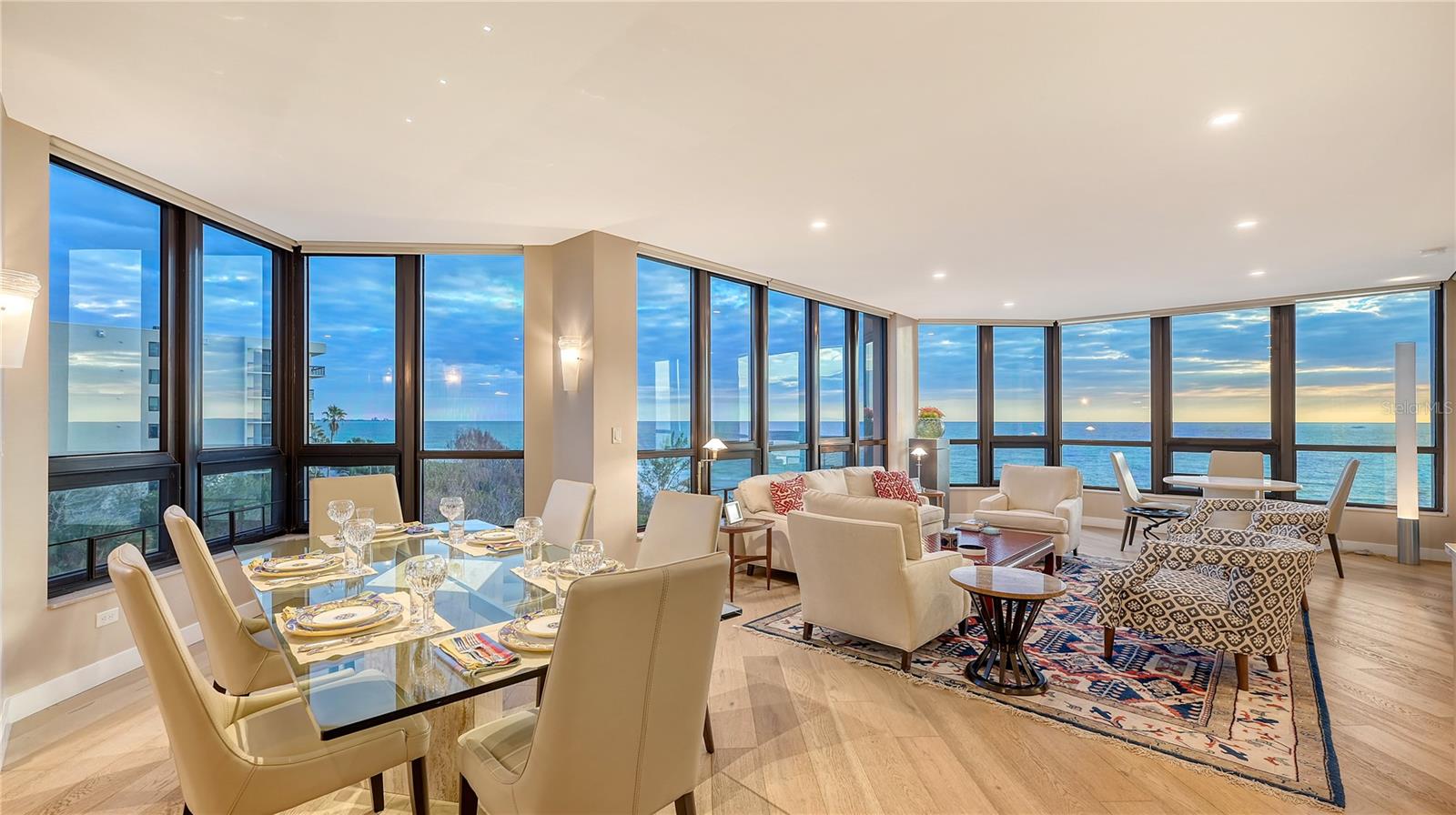 This stunning retreat seamlessly combines modern comfort, contemporary updates, and breathtaking panoramic beach views. Two well-placed terraces create the perfect setting to savor spectacular sunset vistas. Enter through double doors and you’re immediately greeted by awe-inspiring Gulf views that stretch across this nearly 2,300-square-foot residence, offering a captivating sense of openness and serenity. Walls of floor-to-ceiling glass and soaring ceilings amplify the sweeping Gulf vistas, allowing natural light to flow freely throughout the home. Beautiful oak engineered hardwood floors connect the spaces, creating a seamless and inviting layout. The extended foyer leads into a thoughtfully designed living/dining area featuring custom built-ins, a wine cooler, and access to the Gulf-facing terrace. Nearby, an informal dining area flows effortlessly into the chic, updated kitchen, where sleek custom cabinetry, granite countertops, stainless steel appliances, and a tile backsplash make this a chef’s dream. Three-bedroom residences are a rare find at The Promenade, and this home’s configuration delivers comfort and privacy. Each bedroom boasts its own upgraded en-suite bathroom. The primary suite is a private sanctuary, complete with terrace access, dual walk-in closets, a built-in desk or makeup station, and a spa-inspired quartz bathroom. The second guest suite enjoys its own Gulf terrace access and features a spacious walk-in closet. The third bedroom is currently styled as a cozy den. Convenience is key, with covered under-building parking and a dedicated storage unit. The Promenade redefines beachside living, offering a resort-style experience designed to elevate every aspect of your lifestyle. On-site management, a full-service concierge, and a secure lobby with a 24-hour manned guard gate provide unparalleled service and peace of mind. Residents enjoy access to a state-of-the-art fitness center, social rooms, and health club facilities. Outdoor amenities include four Har-Tru tennis courts, a Gulfside sundeck, and an oversized heated swimming pool and spa, creating endless opportunities for recreation and relaxation. A private boardwalk leads to the beach, where Tiki huts and pristine sands await, completing the perfect coastal lifestyle.
