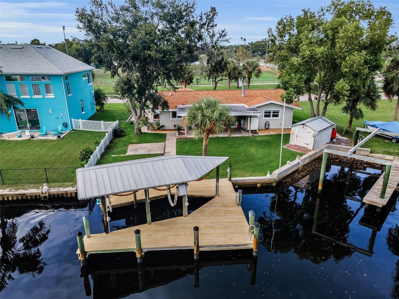 One or more photo(s) has been virtually staged. One or more photo(s) has been virtually staged. Pride of ownership is evident with the care and quality workmanship of this Completely Renovated Waterfront Retreat with 89 feet of prime canal frontage, providing direct access to the Bayous, Anclote River, and Gulf of Mexico. Perfect for boating enthusiasts with a private dock with 22pilings under that dock! And a 12,000 lb. boat lift, sturdy seawall, and property ownership extending into the water. The home features a wall of sliding glass doors with clear hurricane shutters. Stunning water views, 2bedrooms, 2 baths, and an oversized 1-car garage (18x26) with a long, wide driveway for multiple vehicles, trucks, or an RV. The attic offers additional storage space and has a pull-down ladder and attic lights. **RECENT UPDATES include a new roof, HVAC, ductwork, water heater, hurricane impact windows, updated kitchen and baths with granite countertops, all new appliances, LVP Flooring in the bedrooms. fresh interior paint, a new washer/dryer, stylish finishes, and designer lighting.** The spacious open layout offers a cozy wood-burning fireplace, easy care tile and LVP flooring throughout. Enjoy outdoor living with a pavered front porch, covered back porch with ceiling fans, large shed, rain barrel, and a fenced backyard with room for a pool and that beautiful waterfront view. No HOA or deed restrictions to hinder your lifestyle. Located just blocks from Craig Park and minutes from Fred Howard Park, Sunset Beach, The Pinellas Trail, downtown Tarpon Springs, and the world-famous Tarpon Springs Sponge Docks. Enjoy nearby dining, shops, golfing, and great schools. Only 30-45minutes to Tampa International Airport. In Tarpon Springs you have all of the Conveniences of a Big City in a Community that has maintained its Old-World Charm. Whether you’re relaxing indoors with gorgeous water views, entertaining on the scenic back porch, or heading out for a sunset cruise, this home delivers the ultimate Florida lifestyle.