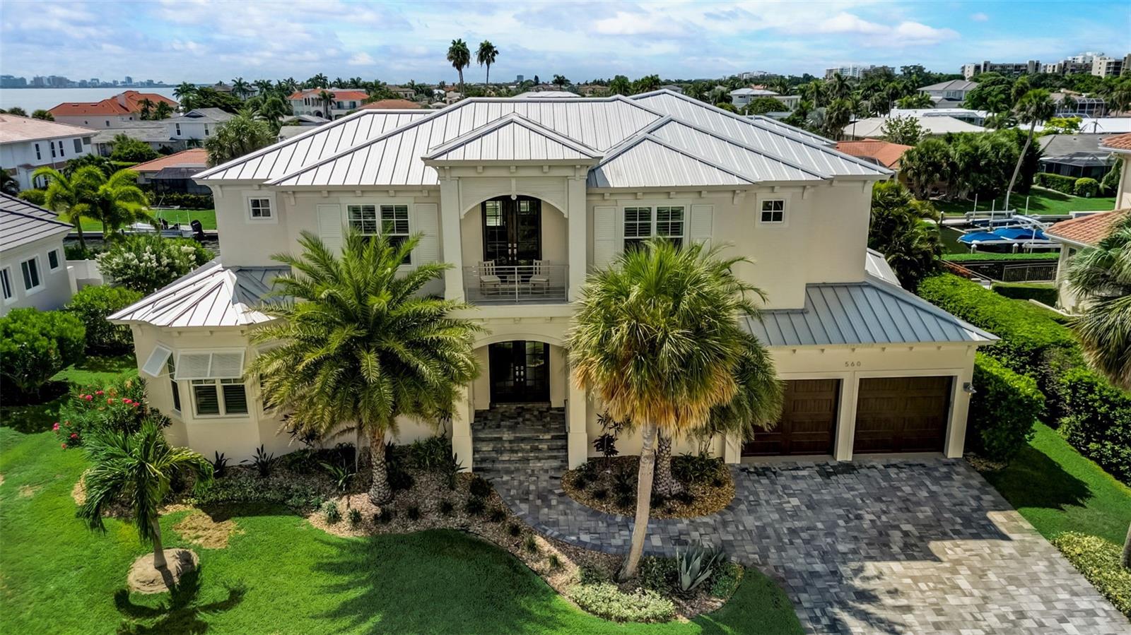Welcome to your West Indies-style waterfront estate, offering island life at its finest! Epitomizing Southwest Florida's relaxing tropical lifestyle, this impeccably constructed 2018 custom built and fully furnished 4 BR & 4.5 BA residence is perfectly positioned with 105' of saltwater canal water frontage with the open waters of Sarasota Bay and the Gulf of Mexico just a quick ride away. As you step through the double doors into this light-filled home, you will notice its architectural details,, open concept floor plan, beautiful blonde hardwood floors, built-in cabinetry and exceptional integration of the indoor/outdoor living experience with expansive decks, covered sitting areas, a summer kitchen, gas fire pit sitting area and sparkling heated saltwater pool and spa. With over 4,300 square feet of coastal elegance on 2 levels, there is plenty of room for family and friends and the design includes 2 full Master Bedroom Suites, one on the main floor and the second one upstairs, giving you flexibility. There is even an elevator, which will make it very easy to get luggage from the 2nd floor to the garage. Your gourmet kitchen opens to the living and breakfast areas and features a spacious quartz-topped island, GE Monogram appliances, including a dual fuel convection oven and a large walk-in pantry. There is also a separate dining room to meet all your entertaining needs. The first-floor Master Bedroom suite offers two walk-in closets and a spa-like Master Bath with dual quartz-topped vanity, free-standing tub and spacious walk-in shower. From your Master Bedroom suite, step onto the lanai through the impact-glass sliding doors and enjoy a morning or evening swim, before relaxing in your private retreat. As you walk up the open staircase to the 2nd floor, you are welcomed by a center loft area, perfectly situated for shared activities with family and surrounded by 3 en-suite guest quarters (including the 2nd Master Bedroom Suite), all exquisitely furnished and decorated. Your upstairs Master Bedroom Suite features a private balcony with a gorgeous water view, 2 walk-in closets and a Master Bath with capacious walk-in shower and separate soaking tub. Additional features include an open office area and large laundry room and guest powder room on the main level, plantation shutters throughout, power blinds with remote on main level, retractable screen on deck, screened-in outdoor sitting and dining area, lush tropical landscaping including a fenced backyard, zone dual A/C and oversized 2-car garage with workbench, on-demand gas water heater and plenty of room for all your outdoor toys. Pamper your guests with a boat ride (power boat is available for purchase under a separate purchase agreement), leaving from your private dock with 10,000 lb boat lift (water and electricity are right there at the dock) and make your way to the open waters of Sarasota Bay. Country Club Shores is one of Longboat Key's most prestigious neighborhoods, offering deep-water canals and exclusive deeded beach access (across Gulf of Mexico Drive) to its residents. With easy access to St. Armand's Circle with its quaint shops and restaurants and just a short drive away from the cultural amenities of Sarasota, Longboat Key residents enjoy the best our area has to offer. Schedule your personal showing today!
