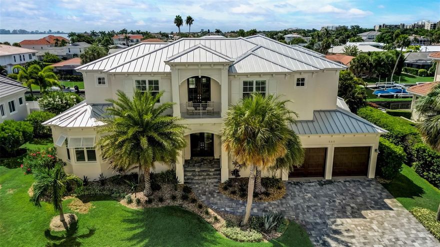 Welcome to your West Indies-style waterfront estate, offering island life at its finest! Epitomizing Southwest Florida's relaxing tropical lifestyle, this impeccably constructed 2018 custom built and fully furnished 4 BR & 4.5 BA residence is perfectly positioned with 105' of saltwater canal water frontage with the open waters of Sarasota Bay and the Gulf of Mexico just a quick ride away.  As you step through the double doors into this light-filled home, you will notice its architectural details,, open concept floor plan, beautiful blonde hardwood floors, built-in cabinetry and exceptional integration of the indoor/outdoor living experience with expansive decks, covered sitting areas, a summer kitchen, gas fire pit sitting area and sparkling heated saltwater pool and spa.  With over 4,300 square feet of coastal elegance on 2 levels, there is plenty of room for family and friends and the design includes 2 full Master Bedroom Suites, one on the main floor and the second one upstairs, giving you flexibility.  There is even an elevator, which will make it very easy to get luggage from the 2nd floor to the garage. Your gourmet kitchen opens to the living and breakfast areas and features a spacious quartz-topped island, GE Monogram appliances, including a dual fuel convection oven and a large walk-in pantry.  There is also a separate dining room to meet all your entertaining needs.  The first-floor Master Bedroom suite offers two walk-in closets and a spa-like Master Bath with dual quartz-topped vanity, free-standing tub and spacious walk-in shower.  From your Master Bedroom suite, step onto the lanai through the impact-glass sliding doors and enjoy a morning or evening swim, before relaxing in your private retreat.  As you walk up the open staircase to the 2nd floor, you are welcomed by a center loft area, perfectly situated for shared activities with family and surrounded by 3 en-suite guest quarters (including the 2nd Master Bedroom Suite), all exquisitely furnished and decorated. Your upstairs Master Bedroom Suite features a private balcony with a gorgeous water view, 2 walk-in closets and a Master Bath with capacious walk-in shower and separate soaking tub.  Additional features include an open office area and large laundry room and guest powder room on the main level,  plantation shutters throughout, power blinds  with remote on main level, retractable screen on deck, screened-in outdoor sitting and dining area, lush tropical landscaping including a fenced backyard, zone dual A/C and oversized 2-car garage with workbench, on-demand gas water heater and plenty of room for all your outdoor toys.  Pamper your guests with a boat ride (power boat is available for purchase under a separate purchase agreement), leaving from your private dock with 10,000 lb boat lift (water and electricity are right there at the dock) and make your way to the open waters of Sarasota Bay.  Country Club Shores is one of Longboat Key's most prestigious neighborhoods, offering deep-water canals and exclusive deeded beach access (across Gulf of Mexico Drive) to its residents.  With easy access to St. Armand's Circle with its quaint shops and restaurants and just a short drive away from the cultural amenities of Sarasota, Longboat Key residents enjoy the best our area has to offer.  Schedule your personal showing today!