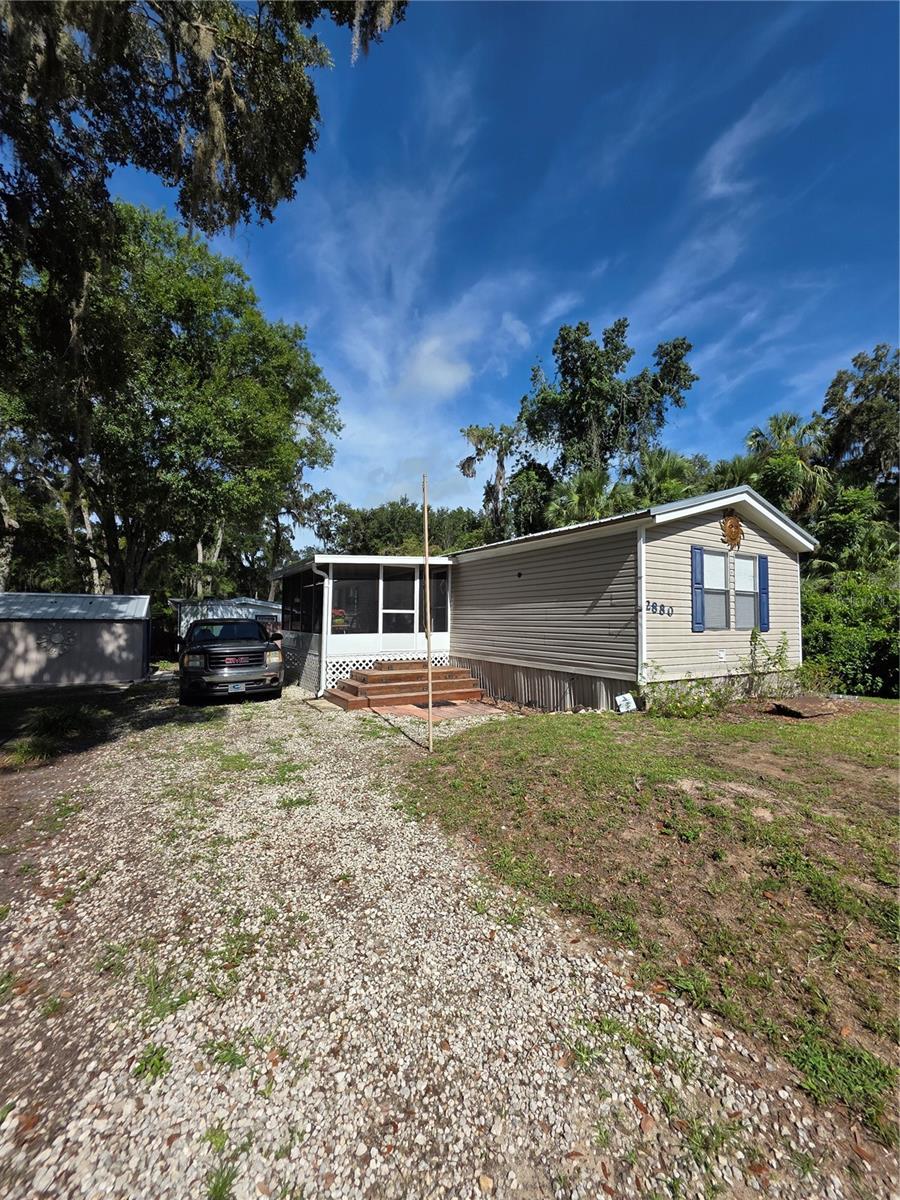 Charming and well maintained 2 bed, 2 bath manufactured home, offering 1,056 sq ft of living space on a
spacious 0.21-acre lot in the peaceful Panacoochee Retreats community of Lake Panasoffkee. This inviting
property features an open concept living and dining area, a functional kitchen with ample cabinet and counter
space, and a large gravel driveway with plenty of parking. A screened in porch adds the perfect spot to relax
outdoors while staying shaded and bug free, and a convenient storage shed provides extra space for tools,
lawn equipment, or seasonal items. Surrounded by mature trees, the home offers privacy and a serene setting
ideal for gardening, entertaining, or simply enjoying the Florida lifestyle. With no HOA fees and easy access to
major roads, this property is an excellent option as an affordable full time residence, seasonal retreat, or rental
investment. SCHEDULE YOUR SHOWING TODAY!