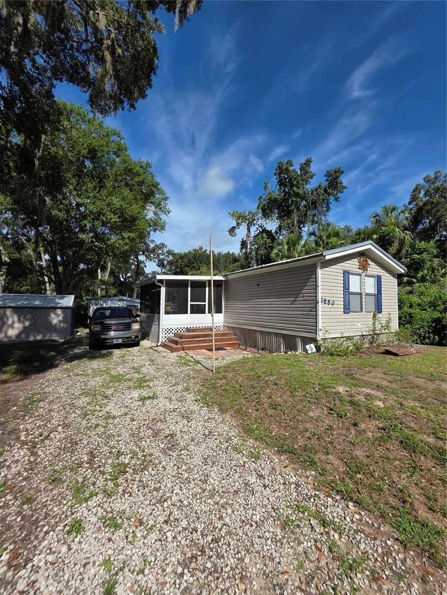 Charming and well maintained 2 bed, 2 bath manufactured home, offering 1,056 sq ft of living space on a
spacious 0.21-acre lot in the peaceful Panacoochee Retreats community of Lake Panasoffkee. This inviting
property features an open concept living and dining area, a functional kitchen with ample cabinet and counter
space, and a large gravel driveway with plenty of parking. A screened in porch adds the perfect spot to relax
outdoors while staying shaded and bug free, and a convenient storage shed provides extra space for tools,
lawn equipment, or seasonal items. Surrounded by mature trees, the home offers privacy and a serene setting
ideal for gardening, entertaining, or simply enjoying the Florida lifestyle. With no HOA fees and easy access to
major roads, this property is an excellent option as an affordable full time residence, seasonal retreat, or rental
investment. SCHEDULE YOUR SHOWING TODAY!