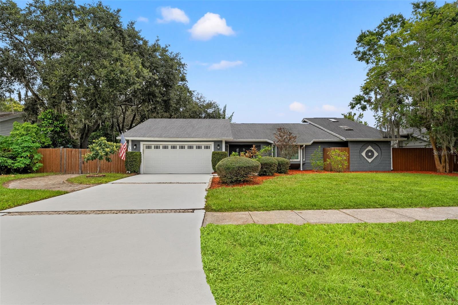 Welcome to this charming 5-bedroom, 3-bathroom pool home, nestled in the highly sought-after Whispering Lakes community in Tarpon Springs. From the moment you enter, you’re greeted by a spacious foyer, beautiful travertine tile flooring, and soaring vaulted ceilings. Also, a unique atrium complete with a tranquil fountain offering a serene focal point—where you might welcome the presence of birds, adding a touch of nature and calm to your daily living experience. The main living area features porcelain tile floors, custom built-in cabinetry, a wine/beverage cooler, and a cozy electric fireplace, perfect for relaxing and unwinding. Just off the living room, the formal dining area boasts its own wood-burning fireplace, adding warmth and character. The kitchen is a chef’s delight with granite countertops, a center island, pantry, plenty of cabinetry for storage, and stainless steel appliances. Enjoy pool views and natural light from the kitchen’s oversized windows and adjoining casual dining space. A second living area near the kitchen also showcases pool views and provides a flexible layout for entertaining. One of the five bedrooms is conveniently located here, ideal as a home office or guest room with views.
The primary suite, privately situated off the main living room, features dual closets (including a large walk-in), and a spa-inspired en-suite bathroom with dual vanities, an elegant walk-in shower with dual shower heads, a built-in bench, and designer accents. Step outside to your screened-in outdoor oasis with a sparkling pool, heated spa, and fenced yard with a playset—all situated in front a peaceful pond which could make for the perfect view. The home also includes a two-car garage and extended driveway for ample parking. As a bonus, your backyard gate opens up directly to the community park, complete with pickleball and basketball courts—an amenity few homes offer. With A-Rated Schools and easy access to top-rated beaches, highways, airports, restaurants, shopping, golf, and more, this home truly offers the perfect blend of comfort, lifestyle, and location. Don’t miss this opportunity, schedule your showing today!