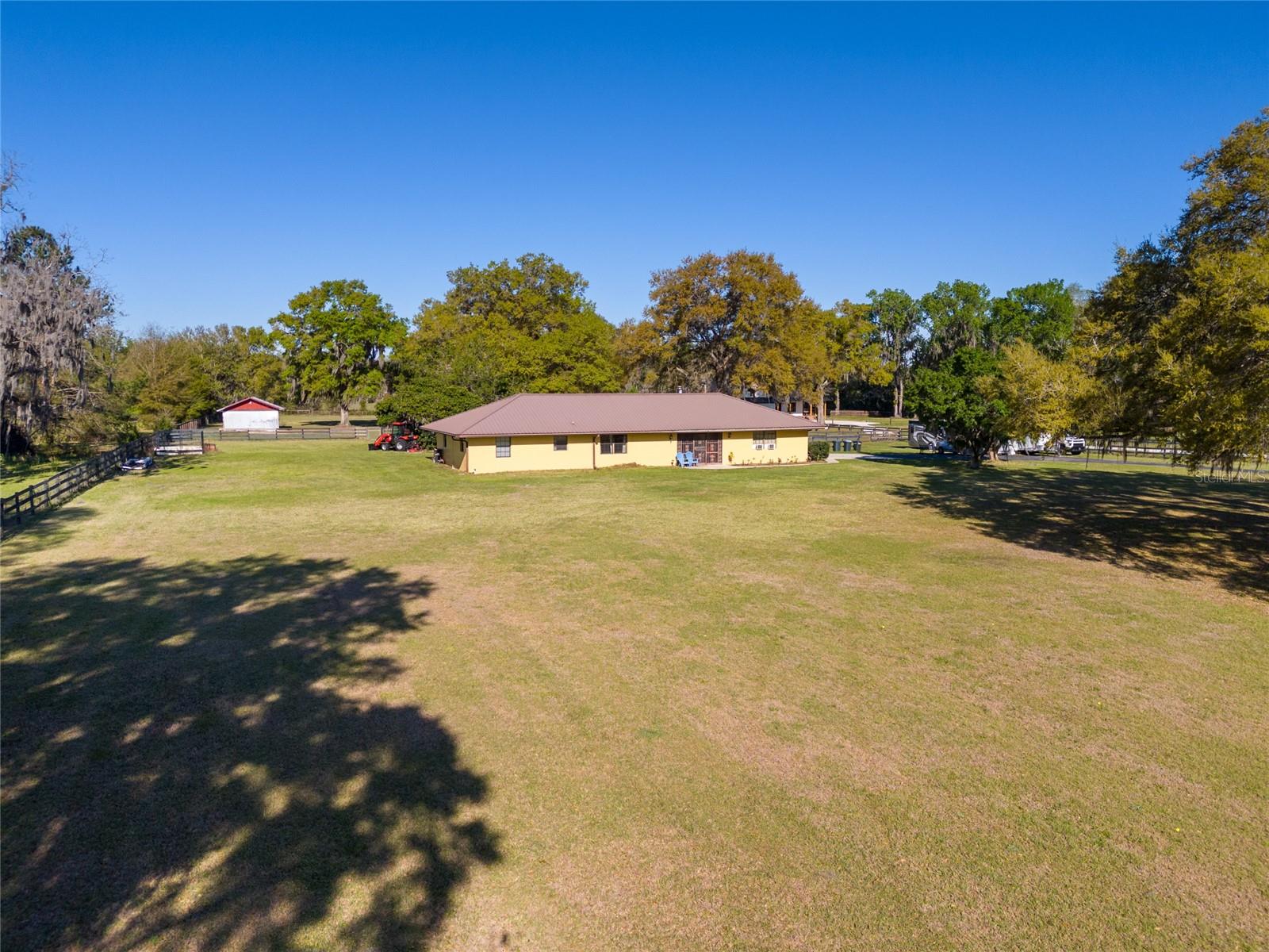 Discover this stunning 4.9-acre equestrian estate, just minutes from the renowned World Equestrian Center in Marion County, the unrivaled horse capital of the world. As you enter through the gated, paved driveway, you'll be captivated by the picturesque surrounding horse farms. This charming 3-bedroom, 2-bathroom home is ideally positioned on nearly 5 acres of pristine land, offering the perfect blend of comfort and natural beauty. Cozy up by the wood-burning stove in the living room during the mild Florida winters, or unwind on the lanai, taking in breathtaking views of the barn/workshop during the warmer months. The home features a newer metal roof, an HVAC system updated in 2012, a modern hot water tank, and newer fresh paint. Majestic oak trees dot the landscape, while the property is fully fenced and cross-fenced for added convenience and security. Brimming with character, this exceptional home awaits its new owners. Contact us today to schedule your exclusive private tour!