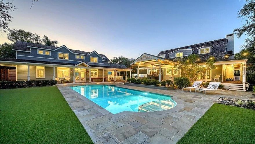 Welcome to this rarely available Cape Cod–style residence, comprised of a masterfully renovated main house and separate luxe guest house poised on an expansive 20,000 sq. ft. lot in Sarasota’s prestigious Cherokee Park. Elevated 23 feet above sea level and nestled on a wide, tree-lined street in the coveted West of Trail district—within the top-rated Southside school zone—this 4-bedroom, 3 full/2 half bath +office private compound blends timeless architecture with designer-curated sophistication. A stately front porch framed by lush landscaping and classic brick walkway introduces the home with understated grandeur. Handcrafted, glass-inlaid iron double doors open to a refined foyer where natural light, elegant millwork, and soaring 10-foot ceilings set the tone for the bespoke interiors beyond. Inside, original hardwood floors, designer lighting by Arteriors, Eichholtz, and Kelly Wearstler, and high-end finishes selected by Chelsea Dunbar of Blu Interiors create a sense of warmth and refinement throughout. The quartz-clad chef’s kitchen is as functional as it is beautiful, featuring a Wolf natural gas range, KitchenAid French-door refrigerator, ample pantry space, and custom cabinetry—perfectly suited for both intimate dining and entertaining. Anchored by a wood-burning fireplace, the main living and dining spaces flow seamlessly outdoors to an inviting Pennsylvania bluestone patio, low-maintenance Astroturf lawn, and wrap-around Brazilian teak deck—an idyllic setting for year-round enjoyment. The serene first floor primary suite is a private retreat showcasing three custom-designed walk-in closets and a spa-inspired bath with marble finishes, dual vanities, heated towel bar, and a zero-entry shower with body sprays. Ascend the custom staircase to find 2 tailored guest retreats with spa-like bath, each offering serene views and thoughtfully appointed details for ultimate comfort and privacy. Throughout the home, custom wallcoverings by Phillip Jeffries, Scalamandré, and Élitis add layers of texture and artistry, while upgraded systems—including a surround sound system, six climate zones, and multiple laundry areas—enhance everyday comfort. Resort-style living continues outdoors with a 9-foot-deep pool framed by classic Bevolo gas lanterns and an extraordinary luxury guest house built in 2016. This refined space includes an entertaining area with custom built-ins, full bar, refrigerator drawers, Scotsman icemaker, private guest suite, 1.5 baths, gym, and an outdoor teak shower. The fully equipped outdoor kitchen features a natural gas Lynx grill, XL Green Egg, quartzite prep counters, and a covered gazebo ideal for al fresco dining. All impact doors and windows, cedar shake roof, and Hardie Board siding add to the beauty and durability of the home. Completing this exceptional estate is an oversized 2.5-car detached garage and secure, fully fenced grounds with electric fence. Enjoy tree-lined streets with sidewalks and a true sense of community, all just a short stroll or golf cart ride to Southside Village where residents enjoy boutique shops, Morton’s Gourmet Market, cafés, and top-rated restaurants, and minutes from downtown Sarasota and Siesta Key Beach. This is refined Gulf Coast living—where timeless architecture meets effortless luxury in one of Sarasota’s most treasured neighborhoods.