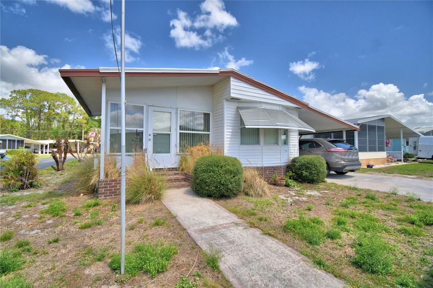 Check out this well maintained home located in Oakwood Estates, a 55+ community, located in Sunny central Florida.  The home features a very open and inviting kitchen, perfect for entertaining.  The cooktop and built in oven have been updated.  Step into the primary bedroom to find plenty of space for a king size bed, then step into the remodeled and updated primary bathroom.  The split bedroom floor plan offers privacy to guests with a bathroom conveniently located outside the door.  All the flooring is a laminate with no carpeting in the home.  Enjoy the peaceful screened side porch.  The home is located on a corner lot with a Florida room giving views of both streets, a great place for your morning coffee.   The double pane windows and window AC offers additional living space when guests arrive.  Oakwood Estates offers many amenities and activities.  You can be as busy as you would like or enjoy the peaceful community and watch the world go by.