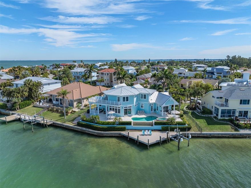 Nestled at the northern-most point in the picturesque shores of Key Royale on Anna Maria Island, this stunning WATERFRONT property embodies the epitome of luxury coastal living. This is an Emily Anne Smith designed home where you are greeted with one of the most perfect floor plans and expansive views of Bimini bay and more.   This 5 bedroom, 4.5 bathroom is so captivating by the seamless blend of elegance and comfort.  In its most pristine condition, the caring owners have loved and kept up the property like it is brand new.  The interior boasts a spacious open floor plan, adorned with high ceilings, oversized windows, and high end finishes throughout. Every detail has been meticulously crafted to create an atmosphere of refined sophistication.  The heart of the home lies in the gourmet kitchen with the long centered island, completed with top-of-the-line appliances including 2 dishwashers, calming colored custom cabinetry perfect for culinary enthusiasts and entertaining guests.  Adjacent to the kitchen, the dining area and living room offers breathtaking views of the waterfront, providing the ideal backdrop including sunsets every night.  With a total of five bedrooms and four and a half baths, there's plenty of room for family and friends to feel right at home.  Each bedroom boasts its own unique charm and character, providing a comfortable atmosphere.  There are many outdoor areas to lounge including a covered patio to enjoy morning coffee and watch the Yacht’s go in and out of Galati’s marina.  Or lounge by the sparkling heated infiniti pool, soak up the sun on the large sundeck, or unwind in the spa while enjoying panoramic views and watching dolphins, manatees, pelicans and more play in the water.  A private dock offers direct access to the bay, perfect for boating, fishing, or simply admiring the sunset.  Located in the prestigious Key Royale community, enjoy many amenities including a golf course, tennis/pickleball courts, and a clubhouse. This is a must see, schedule your private showing today!