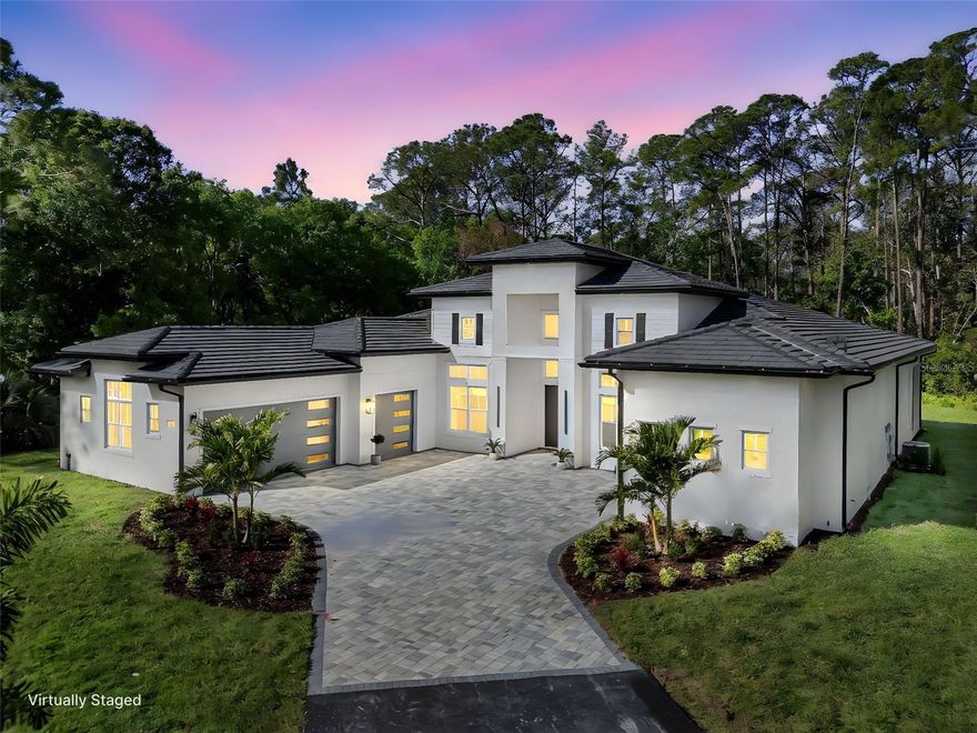 One or more photo(s) has been virtually staged. Brand-new custom-built estate offering 4,179 sq ft of living space (5,558 sq ft under roof) on 5 private acres—never lived in! Ideally located in the sought-after acreage community of Happy Trails, just minutes from Celebration, Reunion, and Walt Disney World, this exceptional property offers the perfect blend of luxury, privacy, and convenience with no HOA restrictions and ample space for horses, recreation, and enjoying your private setting.

Step inside to experience impressive architectural design, highlighted by 24-foot coffered ceilings in the grand foyer and formal dining room, a vaulted ceiling reaching 14 feet in the main living area, and 12–13 foot ceilings throughout, creating a bright, open, and expansive atmosphere.

At the heart of the home is a stunning designer kitchen featuring an oversized island topped with Italian Mona Lisa granite, creating a true centerpiece for entertaining and everyday living. The kitchen is further enhanced by floor-to-ceiling custom cabinetry with illuminated upper display cabinets, a wet bar with wine cooler, and elegant finishes throughout. The open-concept layout flows seamlessly into the main living space, complemented by premium porcelain tile flooring throughout.

The spacious living area features a modern electric fireplace with mantel surround, beautifully complemented by custom built-in cabinetry and designer wall shelving, adding warmth and architectural elegance to the space.

The thoughtfully designed floor plan includes a central living area with a kitchen/family room combo and a desirable split-bedroom layout for added privacy.

The luxurious primary suite is a true retreat, featuring an elegant double-door entry and dual oversized walk-in closets, including a custom “hers” closet measuring approximately 20’8” x 5’6” and a generous “his” closet at 13’8” x 5’8”, both designed with quality wood shelving and mirrored sliding doors.

Additional highlights include Energy Star® certified windows, step-free access throughout, and a beautifully finished paver driveway, walkways, and outdoor living areas. The home is also equipped with a private well system, providing a reliable water source and eliminating monthly water utility costs.

This rare 5-acre estate offers exceptional privacy and space while being conveniently located near world-class dining, shopping, and entertainment.