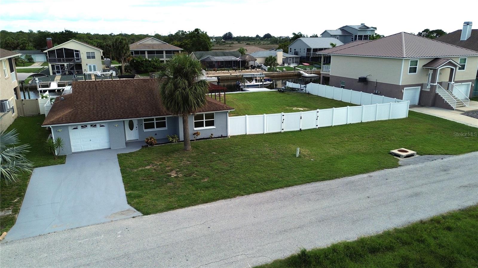Embrace the ultimate boater’s lifestyle with DOUBLE LOTS, DOUBLE BOAT LIFTS, and DOUBLE the WATERFRONT FOOTAGE! (approximately 120 feet of sea wall!) This charming 2 bedroom, 2 bath POOL home will become your private piece of heaven. Step into a bright, open floor plan that offers effortless flow and modern comfort. Beautiful fluid tile flooring runs throughout enhancing the spacious feel and tying each room together seamlessly. The heart of the home is the beautifully appointed kitchen featuring stainless steel appliances and a granite island, perfect for gatherings, prepping or serving up dinner. Step out to the screened in patio, your own private retreat to enjoy ocean breezes, morning coffee or sunset cocktails. Around the pool there is plenty of space to sunbath, entertain and BBQ (an additional covered porch off the master bedroom offers shaded shelter as well as screened patio) or take a refreshing dip in the pool after a relaxing day on the water. For the boater in the family there are TWO BOAT LIFTS, (as well as an additional floating dock) each capable of supporting up to 10,000 lbs, you’ll have effortless water access right from your backyard. Each boat lift conveniently has water and power to make post boating clean up a snap. The home sits on a direct Gulf-access saltwater canal where you can be in the Gulf of America in just a few minutes. Love Florida wildlife? Don’t be surprised to see dolphins or manatees right in your backyard canal! The expansive backyard spans a second, fully privacy-fenced lot—offering a rare blend of space and seclusion. Whether you envision a garden, fire pit or just need room to store your boat, trailer or toys, the possibilities are truly endless. It's a private coastal retreat with all the room you need to live the lifestyle you’ve been dreaming of. If you don’t need the added space, the lots can be DIVIDED and you can sell it or BUILD on it, the choice is yours.