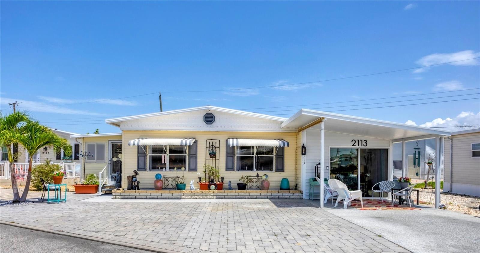 CHECK OUT THIS BEAUTY! It's the perfect opportunity for seasonal or year-round living in this spacious three Bedroom, two Bath Mobile Home on a Lot and a Half in the active 55+ Trailer Estates community. This well-maintained home features layers of Coastal Farmhouse style that adds character and charm. Large Primary Bedroom with ensuite bath. Adding versatility, the 3rd Guest Room is a multi-purpose space that can also serve as a home office, hobby space, or cozy retreat to suit your lifestyle. Luxury vinyl plank flooring throughout. An expansive enclosed climate-controlled lanai is perfect for relaxing or entertaining. All paver front; fenced side and back yards. You own the land. Boaters have direct access to Sarasota Bay from the Marina. Trailer Estates community offers so many options for a great day! Enjoy the large, heated community pool, hot tub, gym and wood shop. The community buzzes with pickleball, shuffleboard, kayaking, horseshoes, bocce, dancing and more. A US Post Office on site. 10 minutes to the SRQ Airport. Convenient to shopping, restaurants, the Arts and everything in Bradenton/Sarasota. Bring offers!