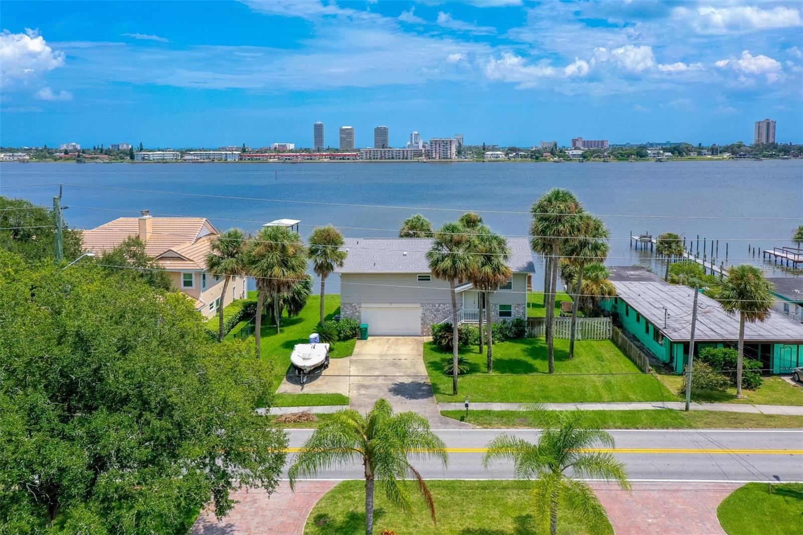 Jump at the chance to own this beautiful and very well priced 3 bedroom 2 ½ bath remodeled home that sits high and dry on the Halifax River/Intracoastal. You can make this your PRIVATE HOME or use it as a LEGAL SHORT-TERM RENTAL. The view is as relaxing as watching the boats sail by. Just imagine sipping your morning's coffee from your waterfront balcony and witnessing beautiful sunrises while watching the dolphins play. There is a dock for fishing, as well as a large back yard with an existing hammock stand. A new roof was installed in 2021. Windows are brand-new impact glass that brings the Halifax River right into your open-concept kitchen, dining and living room areas. There is plenty of room for entertaining. All of the common areas have commercial grade vinyl flooring. This custom-built split-level home boasts an extra-large master suite and huge ensuite bathroom. There is a very spacious patio area downstairs where you can lounge, barbeque and have plenty of room for outdoor dining. The two-car garage is oversized providing ample storage space. The location is fantastic with the beach, shopping, restaurants and the International Speedway all just minutes away.