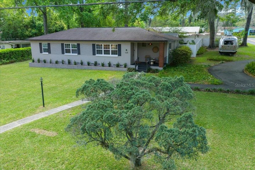Welcome to 1228 NE 17th Ter — a solid 1960 mid-century beauty, thoughtfully renovated while preserving its original charm.
This move-in-ready home showcases its original solid wood flooring, now perfectly refinished, complemented by fresh interior paint and custom wood trim accents throughout. All-new lighting fixtures and ceiling fans add a modern touch while maintaining the home’s timeless character.
The fully updated kitchen and baths feature elegant quartz countertops, designer backsplashes, and stylish finishes. The laundry room has also been upgraded for a cohesive look. Major improvements include updated plumbing, a new roof (2018), and a new A/C system (2021), offering peace of mind for years to come.
Originally designed as a four-bedroom home, the fourth bedroom has been opened to create a flexible open-concept space — ideal as a dining room, home office, or den to suit your lifestyle.
Outdoor living shines with a beautifully renovated front porch and new exterior front door, plus a newly added pergola in the backyard — perfect for entertaining or relaxing. Lush landscaping enhancements complement the property’s mature trees, creating a serene and inviting setting.
Located just minutes from Ocala’s historic district, this home offers the perfect blend of classic mid-century architecture and modern updates in a prime location.