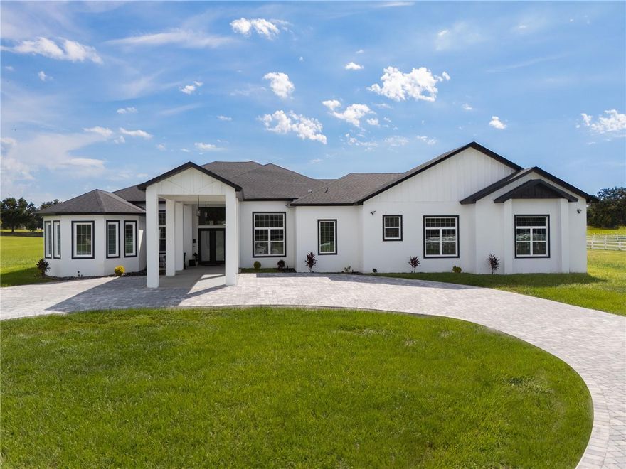 This Custom-Built Luxury Mansion on 5 acres presents a rare opportunity to own over 5,566 sq. ft. of masterfully designed living space in awell known gated equestrian community. From the moment you arrive, the stately architecture, elegant presence, and grand entryway with soaring ceilings set the stage for a lifestyle defined by sophistication and serenity. Inside, the open-concept design is bathed in natural light, blending timeless craftsmanship with modern elegance. The gourmet chef’s kitchen is a true centerpiece, featuring top-of-the-line appliances, a striking leathered granite waterfall island, and abundant storage perfectly suited for both intimate gatherings and large-scale entertaining.
The primary suite is a private sanctuary of luxury, offering spa-inspired finishes, palatial proportions, and an ambiance of pure relaxation. With 6 bedrooms, 5 bathrooms, and a versatile flex space that can serve as a 7th bedroom or executive office, the residence provides unmatched comfort and flexibility. Additional highlights include a covered lanai for sunset evenings, a 4-car garage with ample space for luxury vehicles or hobbies, an 80-gallon commercial water heater, whole-house generator hookup, 6-camera 4K surveillance system with TB IVR, a 64,000-grain Aquasure Harmony water softener, and a surge protector for peace of mind. Designed with both indoor and outdoor living in mind, this home offers multiple spaces to host and entertain in style. Beyond the residence, the 5-acre estate is ideal for equestrian enthusiasts, with meandering bridle paths, expansive open land, and private riding opportunities. As a resident, you’ll also enjoy exclusive access to two private boat ramps, offering direct entry to Lake Morgan and the Lake Emma Chain of Lakes via the Palatlakaha River perfect for peaceful mornings on the water or adventurous afternoons. This estate is more than just a home it’s a statement of elegance, and freedom. For the discerning buyer seeking the perfect balance of luxury living and equestrian passion, this is a once-in-a-lifetime opportunity. Buyer Incentive offered and buyer will receive a 1% interest rate reduction for the first 12 months when using our preferred lender.