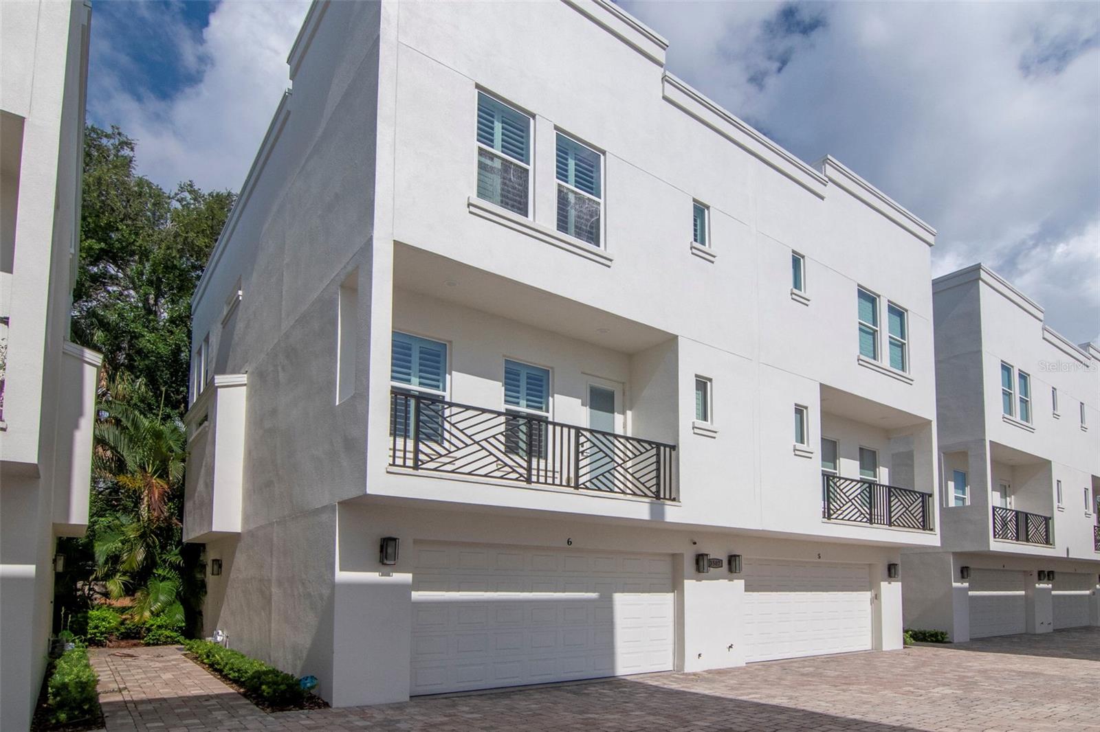 Located just one block from iconic Bayshore Boulevard and Tampa Bay, this beautifully maintained end-unit townhome sits in the heart of South Tampa’s highly coveted Bayshore Beautiful neighborhood and the top-rated Plant High School district. Offering three spacious bedrooms with en suite bathrooms and abundant storage throughout, this residence combines comfort and flexibility with an unbeatable location. The first-floor bedroom functions perfectly as a private guest suite or home office, while the open-concept second floor is flooded with natural light and designed for seamless entertaining. The expansive kitchen includes stainless steel appliances, extensive cabinetry, and a generous walk-in pantry, all connected to a bright dining space with built-in shelving and a stylish serving bar.
Thoughtful details continue with a spacious balcony off the main living area and a private ground-level patio ideal for dining al fresco. The primary suite offers a peaceful retreat with a spa-style bathroom featuring dual vanities and a large, elegant shower. Smart home upgrades throughout include an Arlo video doorbell, Ecobee thermostats, a MyQ-enabled garage door, and Lutron smart lighting. Tucked away from S. MacDill Avenue inside a quiet, well-maintained community, this home delivers a low-maintenance lifestyle with all the benefits of walkable city living. With charming cafés, boutiques, top restaurants, and major destinations like Tampa Riverwalk, Water Street, Amalie Arena, and Tampa International Airport nearby, this is a rare opportunity to enjoy the best of Tampa living in a prime location.