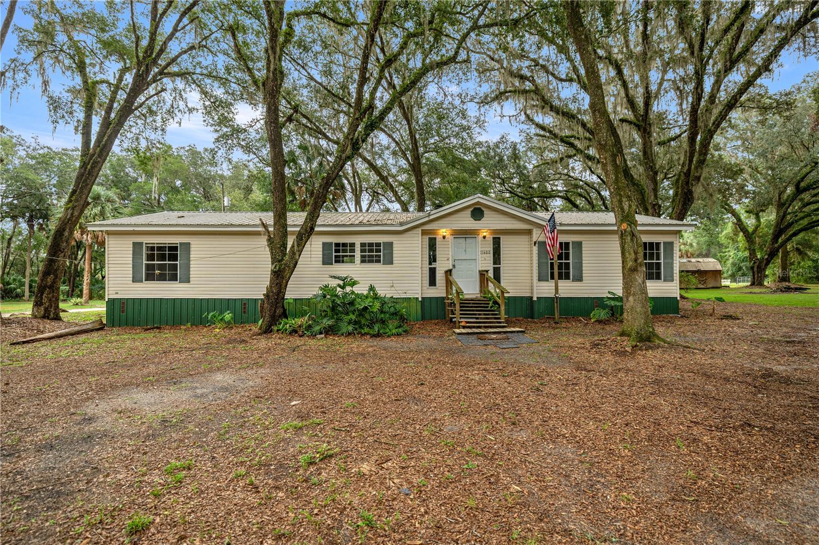 Welcome to this move-in ready, partially renovated 3-bedroom, 2-bath manufactured home on a corner lot shaded by mature oaks. With over 1,700 sq. ft. of living space, the home offers walk-in closets, a cozy wood-burning fireplace, and a spacious layout perfect for comfortable living.
MANY NEW UPDATES! Enjoy peace of mind with a newer metal roof, newer HVAC, fresh interior paint, new LVP flooring, and a freshly manicured yard.
INCLUDES TWO CONTIGUOUS PARCELS WITH MULTIPLE ACCESS POINTS! This property offers paved road frontage for convenience while maintaining seclusion among oaks, palms, and pines—giving you privacy and easy access.
Located just minutes from the Ocala National Forest and popular springs like Silver Glen Springs and Salt Springs, and only 20 minutes from Ocala, this property combines rural tranquility with convenience.
Fort McCoy provides small-town charm with everyday essentials nearby, while Ocala and Palatka offer larger shopping and dining options. Outdoor enthusiasts will love the access to fishing, hiking, trail riding, water sports, and hunting right at their doorstep.
