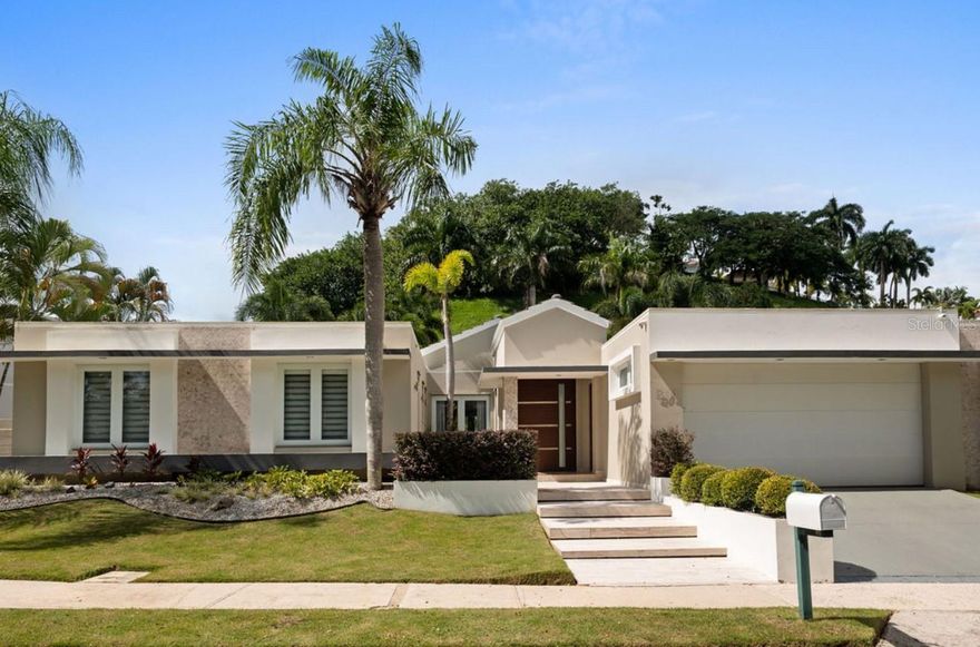 Discover a rare gem in Montehiedra, one of San Juan’s most exclusive neighborhoods. This elegant, modern single-story home features soaring high ceilings and is perfectly situated on a quiet cul-de-sac street for added privacy.

Recently remodeled, the property boasts a stunning kitchen with quartz countertops and top-of-the-line Monogram appliances. Enjoy spacious living with 5 bedrooms plus an office, 3 full bathrooms, and a guest half bath. The master suite impresses with a large walk-in closet and a luxurious bathroom complete with a Jacuzzi tub.

Step outside to a generous terrace with an outdoor kitchen, perfect for entertaining family and friends. Relax in the pool with a built-in Jacuzzi and take advantage of the 3,800 sq ft of living space on a 1,279 m² lot. Additional features include a 34k generator and a water cistern for convenience and peace of mind.
Montehiedra Community Center features tennis court, pickleball, basketball, gym, pool, clubhouse.
The gated community offers 24/7 security with guards conducting preventive patrols.

Experience luxury living in Montehiedra—your dream home awaits!