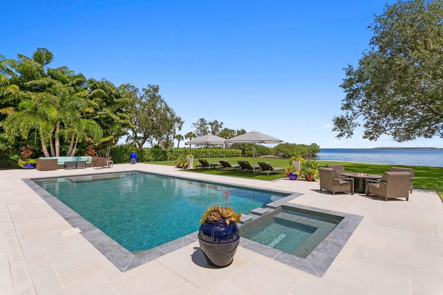 Introducing the perfect private coastal escape in the historic and scenic Ballast Point neighborhood of South Tampa. Be transported via a private road to a tranquil bayfront location surrounded by majestic oaks and inviting Old Florida charm. This estate property spans a FULL ACRE on the open bay and with a rarely found 150 ft. of water frontage. An award-winning coastal design, built by Sample Properties in 2018, welcomes you to refined finishes, dramatic designer appointments and superior outdoor living areas, with 5 bedrooms, 6.5 baths and over 5,000 square feet. Boasting magnificent views from almost every room, you are greeted by a double door entry to light-filled living spaces, great room with fireplace, dining room, warm hardwood floors and designer lighting, along with pecky cypress beam and wood accent ceilings. Sure to please the most discerning chef of the family, the custom kitchen delivers seamless design, center island and quartzite counters, custom cabinetry, integrated appliances (Sub-Zero/Wolf), 6-burner gas range and expansive walk-in pantry overlooking an informal dining/sitting area and water views beyond.  Additional first floor living spaces include a mud room, powder bath and office.  Upstairs, an impressive primary bedroom offers a private terrace, walk-in closet and spacious marble bath with dual vanities, dual water closets and soaking tub. Three additional ensuite bedrooms and laundry room complete the second living level. An intermediate level features a separate private guest/in-law suite offering a generous sitting area, bedroom, stunning bath and walk-in closet. The very best of this marvelous setting awaits outdoors with wide open water views, expansive covered terrace (blue marble), outdoor fireplace, dining area, outdoor kitchen, and pool bath. A heated pool/spa with custom cut limestone pool deck, plus waterfront Ipe deck complete the magazine worthy grounds. Exceptional exterior designed by Levell Design that includes custom railing, landscaping, pool deck, with no expense spared in the extraordinary marine-grade copper Aurora exterior landscape lighting system. Additional appointments include reinforced and recapped seawall 2020, separate cottage with storage and elevated living space (playroom, studio or home gym), along with an expanded 3-car garage. Convenient and walkable to the renowned Tampa Yacht Club, Bayshore Boulevard, Ballast Point park, this superior South Tampa estate delivers the ultimate in Florida Waterfront Living yet proximity to all that the City of Tampa has to offer.
