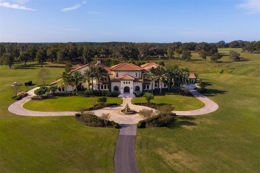 Nestled away on a quiet street in Ocala, this stunning 73+ acre estate offers privacy and convenience, located just 3 minutes from the World Equestrian Center! Fully fenced and thoughtfully designed for equestrian enthusiasts, the property features 10 paddocks, an 18-stall barn with a large barn apartment, feed and tack rooms, a round pen, and a covered arena for year-round training and care. Adding to its charm is a beautifully sodded lime rock quarry, creating a unique and scenic feature on the property. The main residence, a grand mansion, combines elegance and comfort with 7 bedrooms, 7 full bathrooms, and 2 half bathrooms. Upon entering, you are welcomed by a striking foyer with an imperial staircase leading to the second floor. The home includes spacious balconies overlooking the beautifully landscaped pool area, an in-home theater, gym, and a 4-car garage with a carport for additional parking. Designed for relaxation and entertainment, the backyard features an in-ground pool surrounded by a lounge area and a covered outdoor kitchen, perfect for hosting gatherings. This remarkable property offers a rare combination of luxury living and top-tier equestrian amenities, set on a serene street with minimal traffic, surrounded by other iconic Ocala farms!