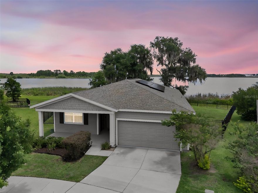 MOVE-IN READY lakefront Next Gen home with a private-entry apartment-style living space, expansive water views, SOLAR PANELS, a FENCED YARD, and a cul-de-sac setting in the Estates at Lake Hammock community. Designed for flexibility and everyday comfort, this 4-bedroom, 3-bath home offers 2,109 square feet of living space with a layout well suited for multi-generational living, extended guests, work-from-home needs, or buyers seeking additional privacy under one roof.

Approaching the home, the covered front porch creates a welcoming entry, while the peaceful lakefront backdrop immediately sets this property apart. Step inside to a bright foyer with neutral finishes and ceramic tile flooring that continues through the main living areas. From the entry, the open layout naturally draws you forward toward the living space, where large sliding glass doors frame the lake view and fill the room with natural light.

The kitchen is open to the main gathering area and features solid-surface countertops, gray cabinetry, stainless steel appliances, recessed lighting, pendant lighting, a breakfast bar with seating space, and generous cabinet and countertop storage. The adjoining dining space provides a comfortable place for everyday meals while maintaining an easy connection to the kitchen and living room.

The spacious great room is designed to keep the lake view at the center of the home. A decorative accent wall adds warmth and character, while the open flow provides room for both relaxing and entertaining. Slide open the glass doors to the covered rear lanai, where the view extends across the backyard to the water beyond. This is a setting made for quiet mornings, outdoor dining, and evenings spent taking in the natural Florida scenery.

A major highlight of this property is the private-entry Next Gen apartment-style space, providing a separate exterior entrance and added flexibility for household needs. This private area creates valuable options for multi-generational living, extended-stay guests, adult family members, a caregiver arrangement, or a more independent home office setup while remaining connected to the main residence.

The primary bedroom is located on the main level, and the home's split-bedroom design adds comfort and privacy. Three additional bedrooms and a total of three full bathrooms provide practical space for residents and guests. The dedicated interior laundry room adds convenience for daily routines, while ceramic tile and carpet flooring are thoughtfully placed throughout the home.

Outside, the fenced backyard opens to a remarkable lakefront setting, with mature trees and wide water views creating a peaceful natural backdrop. The covered lanai provides shaded outdoor living space, and the backyard allows room to enjoy the view, entertain, garden, or spend time outdoors without losing sight of what makes this homesite so special.

Located in the Estates at Lake Hammock, the community includes amenities such as a playground, sidewalks and walking paths, and open green spaces.  For buyers searching for a lakefront Central Florida real estate opportunity or an Orlando relocation home with flexible multi-generational living space, this property provides a distinctive combination of layout, setting, and functionality.

Contact us today for a private tour or more details on this exceptional opportunity.