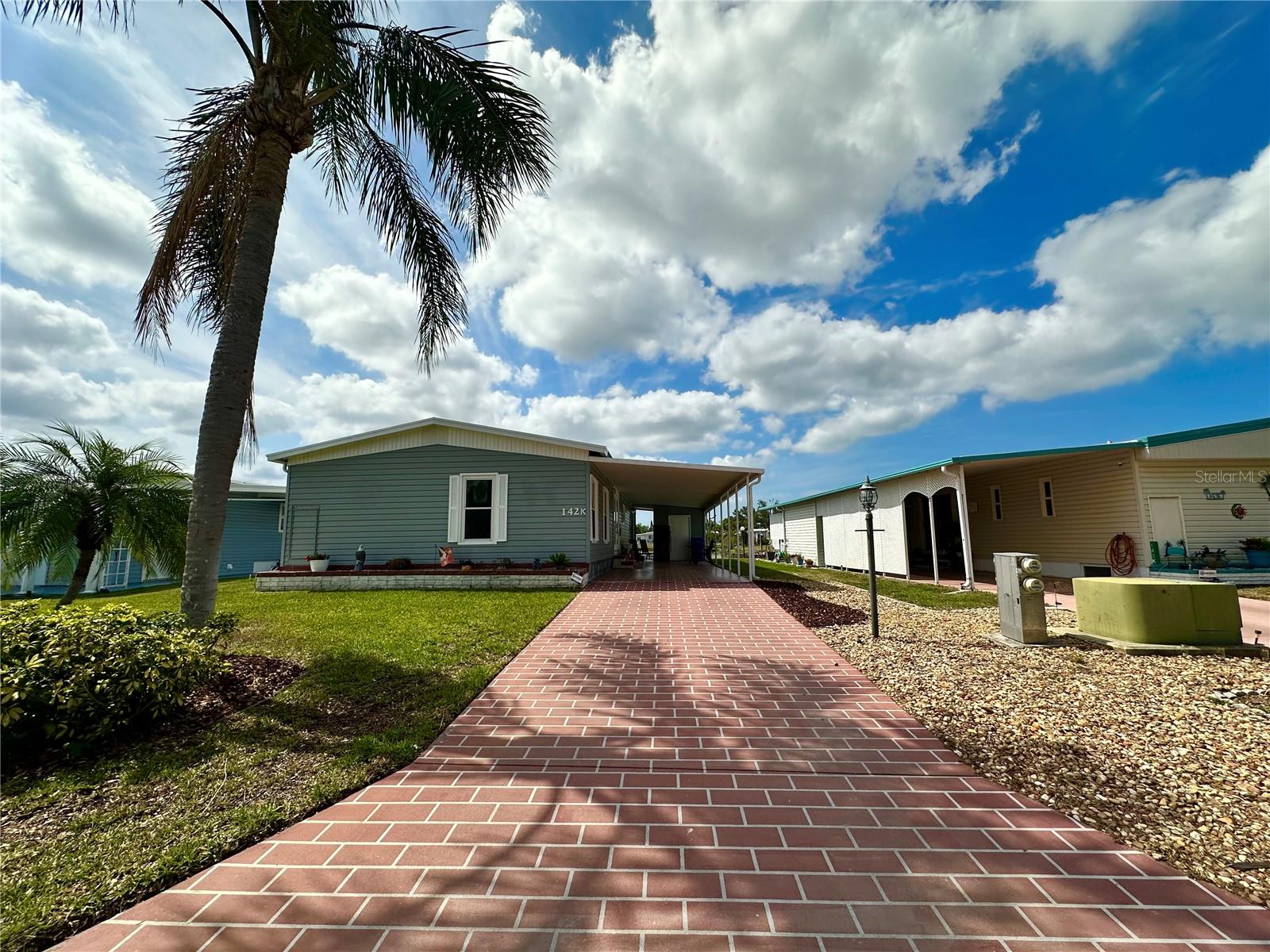 Come check out this MOVE-IN READY WATERFRONT home in the sought after neighborhood of Palm Lake Estates. This 55+ Community is a Low-Maintenance fee community that has NO LOT RENT! This beautifully updated and well maintained home features 2 ensuite bedrooms. The home was replumbed, the electrical panel has been updated, New laminate flooring throughout, Nicely updated kitchen with a new kitchen island, Bathrooms have been updated as well. This home also includes the convenience of having the laundry room inside the home. With a nice paved driveway and a 2 car carport, the home also offers a storage room under the carport. Don't miss the opportunity to own this home.