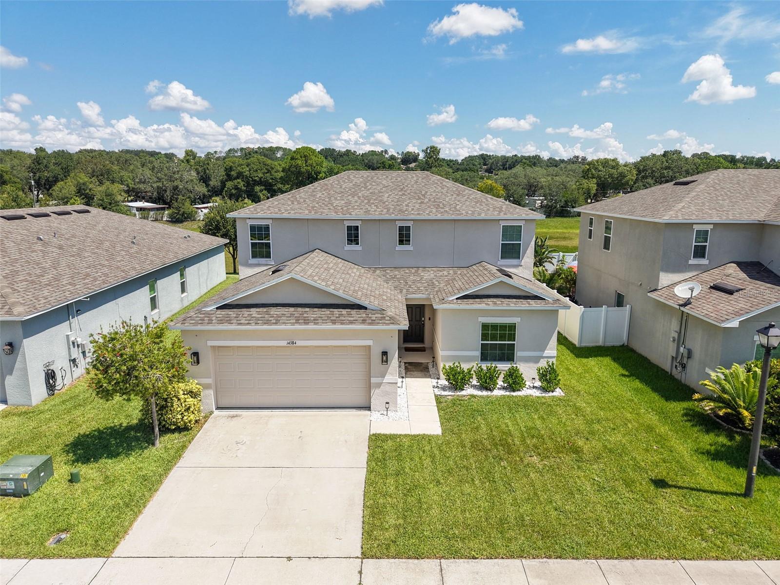 Immaculately maintained 5/3 with 2 car garage in Louisa Grande with no rear neighbors! This 2020 built Redbud model by Taylor Morrison/AV Homes is perfect for entertaining. Kitchen with huge pantry, farmhouse sink, tons of counter space and cabinets, and a large island opening to the family/dining room. There is a bedroom and full bathroom downstairs; perfect for guests. Just off the kitchen and dining area are sliders opening up to the covered patio and back yard with no rear neighbors. Upstairs is the primary suite and 3 additional bedrooms and bathroom. Primary bathroom has dual vanities and a large walk in closet. You will not find a nicer 5 bedroom 3 full bathroom home in this price point in Clermont! Location is fantastic; located near Lake Louisa State Park, shopping, dining, grocery, with nearby parks, trails, lakes, and plenty of activities and within 30 minutes from Disney. Come see it soon!