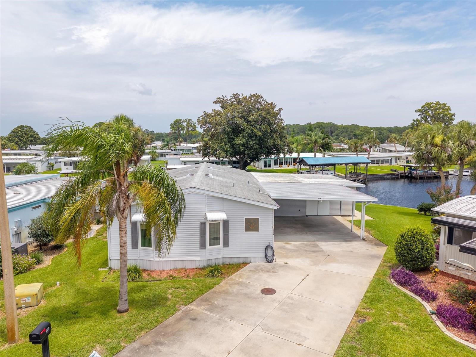 BEAUTIFUL CANAL FRONT LIVING! 2 BED/2 BATH/PLUS OFFICE-DEN FULLY FURNISHED HOME * 55 PLUS * BOATHOUSE, DOCK & LIFT. It’s time to enjoy the life you’ve been waiting for! If waking up and boarding your very own boat just steps away for an early morning cruise gets you excited, you’ll love experiencing all the naturistic sights and sounds as you breeze through one of the deepest and widest canals into the beautiful sparkling waters of the Harris Chain of Lakes! Enjoy the breathtaking water views from the comforts of the oversized Florida Room. This picturesque dream can become reality, living in the meticulous home of this waterfront property. The paradise vibe and scenic views can be seen throughout the home bringing the outdoor beauty into every space - relaxing, dining, entertaining, or YES, even if your snuggling in front of a real wood-burning Fireplace! Love to cook but not secluded... no worries…This open-concept design brings the main living spaces and heart of gatherings central to all! You'll love the convenience of both Kitchen and Florida Room side-by side. The Kitchen – with full-size appliances, island cooktop with breakfast bar, generous cabinet and counter space and stylish eat-in nook - and the huge Florida Room, with sliding door access, will make hosting, serving, and entertaining quick and easy. When you’re ready to call it a day, retire in the privacy of your spacious Primary Bedroom & En-Suite Bathroom, with dual Closets, dual-sink vanity cabinetry, and Walk-in Shower. In addition, a guest Bedroom, an Office/Den/3rd Bedroom (no closet) with great built-in’s, a Full-size Bathroom, and indoor Laundry Room provide the extra space and convenience needed. Outdoor Amenities: Boathouse; Dock with electric Lift; Enclosed Storage; Oversized Parking; and more! Roof 2015; Boat House & Boat Dock 2014; A/C 2010; New Windows 2021. HOA/COMMUNITY: Imperial Terrace is a highly desirable Retirement Community offering AMENITIES galore. Owner reaps sweet rewards with Low HOA Fee – No LOT Rent – You OWN Your Land! The Clubhouse is a favorite with resident Gatherings, BBQ’s, Swimming, Shuffleboard, and much more. A community Boat Ramp provides easy access to the HARRIS CHAIN OF LAKES - perfect for Owners not living on the Canal Front to enjoy Fishing, Boating and fav Water Sports. Imperial Terrace is located off Hwy 441, just minutes from the best in Shopping, Dining, Entertainment, County Offices, and State-of-the-art Medical Facilities, PLUS, renowned local destinations - Mount Dora and The Villages! Easily commute to the Beach Coasts, Orlando attractions, Airports and everywhere exciting that makes Floridians love living Central in the Sunshine State, year ‘round or seasonal. Call to schedule your personal tour today!