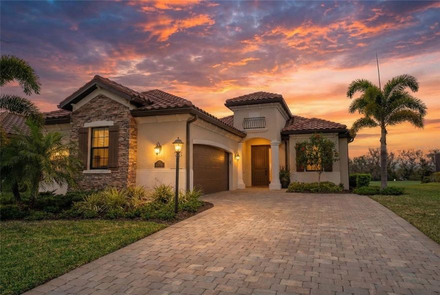 Enjoy expansive golf course views and spectacular western sunsets from this beautifully upgraded Victoria model in one of Lakewood Ranch’s most sought-after deeded golf communities, Lakewood National Golf Club. From the moment you arrive, the home offers inviting curb appeal with a widened paver driveway expanded approximately 18 inches on each side, tile roof, impact-rated windows, mature tropical landscaping, and a side-yard easement providing additional space between neighboring homes. Inside, the open-concept layout features tile plank flooring throughout the main living areas, tray ceilings with crown molding, designer lighting, and a spacious great room that flows seamlessly into the kitchen and dining areas. The kitchen showcases white cabinetry, granite countertops, stainless steel appliances, and a spacious center island with seating that anchors the open living space, perfect for everyday living and entertaining. The adjacent dining space is highlighted by a designer chandelier, creating a welcoming setting for gatherings. A custom beverage bar with wine refrigerator and glass shelving adds a stylish touch, while the great room is highlighted by a designer feature wall with shelving. The primary suite offers golf course views, tray ceiling, walk-in closet, and an en-suite bath with dual vanities, soaking tub, walk-in shower, and a private water closet. A private den with glass French doors and custom built-ins provides flexible space for a home office or media room. The guest bedroom with plantation shutters is located near a full guest bathroom, offering comfortable accommodations and privacy for visitors. Step outside to the extended 35' x 25' screened lanai with paver deck and upgraded panoramic screen enclosure, designed for true Florida indoor-outdoor living. This impressive space includes multiple seating and dining areas and a fully equipped outdoor kitchen with grill, vent hood, and beverage refrigerator. The panoramic screen enclosure maximizes expansive golf course views and spectacular western sunsets, creating a perfect setting for relaxing or entertaining. A convenient lanai half bath provides easy access for outdoor gatherings, and the outdoor space offers room to add a pool, if desired. Additional highlights include custom electric shades in the living room and primary bedroom, plantation shutters, epoxy garage flooring with overhead storage racks, designer lighting, and thoughtful finishes throughout. Golf membership conveys with ownership. Lakewood National Golf Club is the only deeded golf community in Lakewood Ranch where ownership for all residents includes access to two Arnold Palmer–designed 18-hole championship courses, one of which hosts the annual Korn Ferry Tour event. Residents enjoy a beach-entry heated lagoon pool with waterfalls and lap lanes, six satellite pools, tiki bar, Grand Clubhouse dining, state-of-the-art fitness center with studios and trainer, spa services, Har-Tru tennis courts, pickleball, bocce, practice facilities, scenic trails, and a vibrant community calendar. Completed in 2022, the community is fully established and professionally managed with 24-hour guard-gated entry and roaming security. An exceptional opportunity to enjoy the Lakewood National lifestyle.
