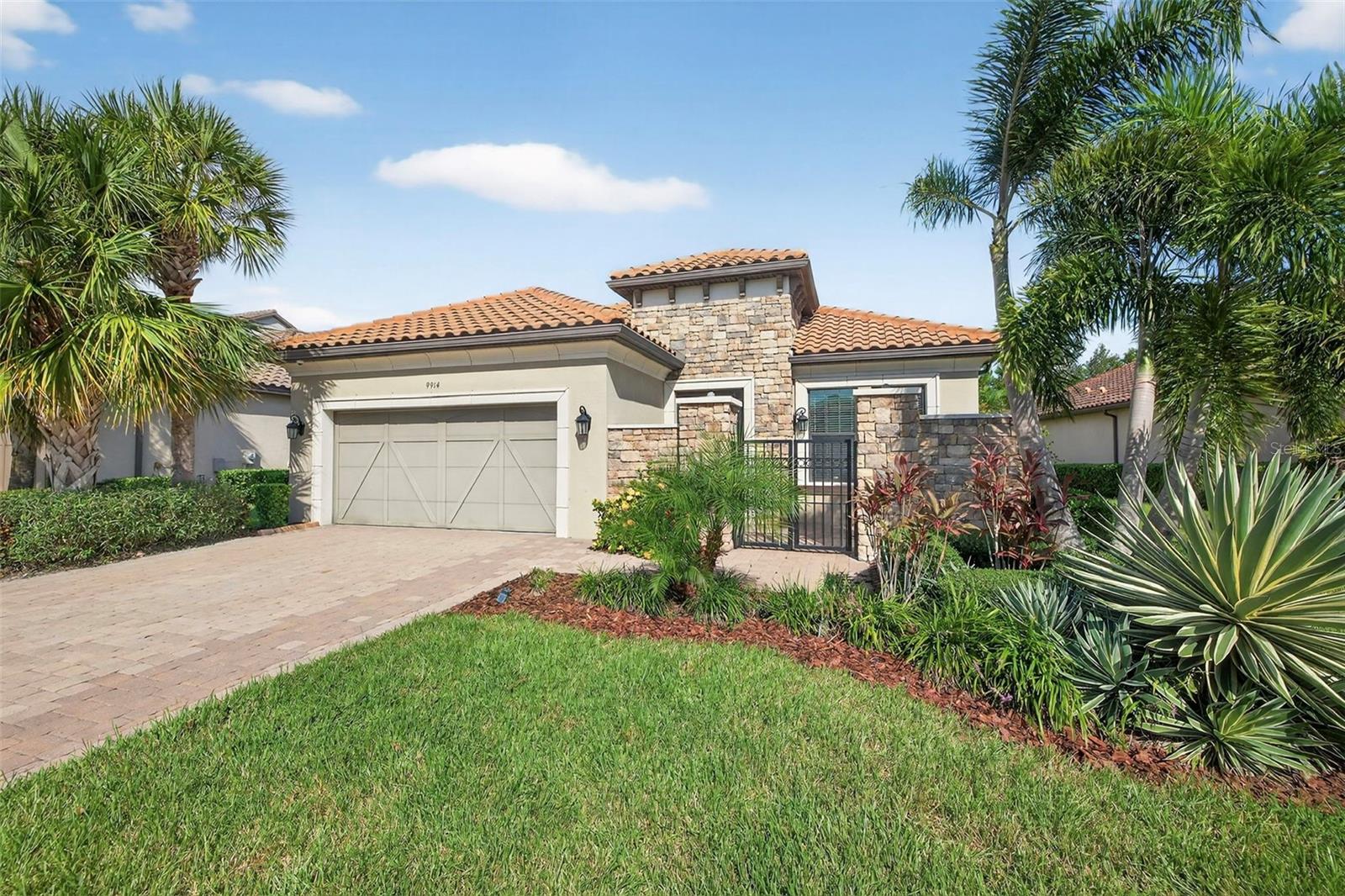 Welcome to this custom built beauty, secluded preserve lot with no rear neighbors, this stunning Taylor Morrison Lazio VII home combines refined design, thoughtful functionality, and meticulous upkeep. Boasting 3 bedrooms, 3 full baths, 2,248 square feet of sleek living space and a 2 car attached garage. Every detail has been crafted to create a move-in ready abode that feels both luxurious and inviting, highlighted by Luxury vinyl plank flooring and freshly painted interior with a bright neutral colors throughout. Brick-accented façade and gated front patio set the tone, welcoming guests into a bright and inviting foyer. Inside, the open-concept layout unfolds with sophistication, where soaring ceilings with custom designer wood touches, expansive windows, and elegant finishes create a light-filled atmosphere ideal for both relaxation and entertaining. At the heart of the home, the chef-inspired kitchen delivers both beauty and performance. A expansive center island with seating invites gatherings, while granite countertops, a stylish tile backsplash, and a custom-organized wood pantry elevate both form and function. High-end stainless-steel appliances complete the space, including a gas cooktop with stainless hood vent system, built-in oven and microwave, French-door refrigerator, and dishwasher. Seamlessly adjoining, the spacious living room accommodates formal dining area as well as casual lounging, extending to the private screened lanai. Step outside to discover a personal outdoor retreat designed for enjoyment in every season. A custom summer kitchen with abundant storage and a brick paved deck provides the ultimate entertaining hub, while the hot tub and surrounding lush landscaping provide a tranquil escape in total privacy. Inside, the home continues to impress with spaces tailored to modern living. A dedicated office/flex space, enclosed by French doors and filled with natural light, creates a comfortable and inspiring enviroment. The primary suite is a true sanctuary, boasting a custom-organized walk-in closet, spa-like bath with dual granite-topped vanities, oversized walk-in glass shower, and private water closet. Two generously proportioned bedrooms and two additional bathrooms ensure comfort and flexibility for family and visitors. The oversized laundry room, complete with extensive storage solutions, enhances everyday convenience. Set within the gates of Esplanade at Artisan Lakes, this residence offers far more than a home—it delivers an enviable Luxury lifestyle. Spanning 800 acres of pristine preserves, sparkling lakes, and scenic walking and biking trails, as a resident, you can enjoy two amenity centers, each thoughtfully appointed with resort-style features including pools and spas, tennis, pickleball, bocce ball, and shuffleboard courts. A state-of-the-art fitness center, wellness programs, pet park, playground, and a vibrant calendar of social clubs and events ensure there’s something for everyone. Located in an unbeatable corridor between Tampa Bay and Bradenton, with easy access to I-75, this beautiful home provides quick connections to Lakewood Ranch, downtown Bradenton, St. Petersburg, and Florida's award-winning Gulf Coast beaches. Combining exceptional craftsmanship, a private preserve setting, and resort style amenities, this charming residence provides the rare opportunity to embrace Florida Luxury living at it's best.
