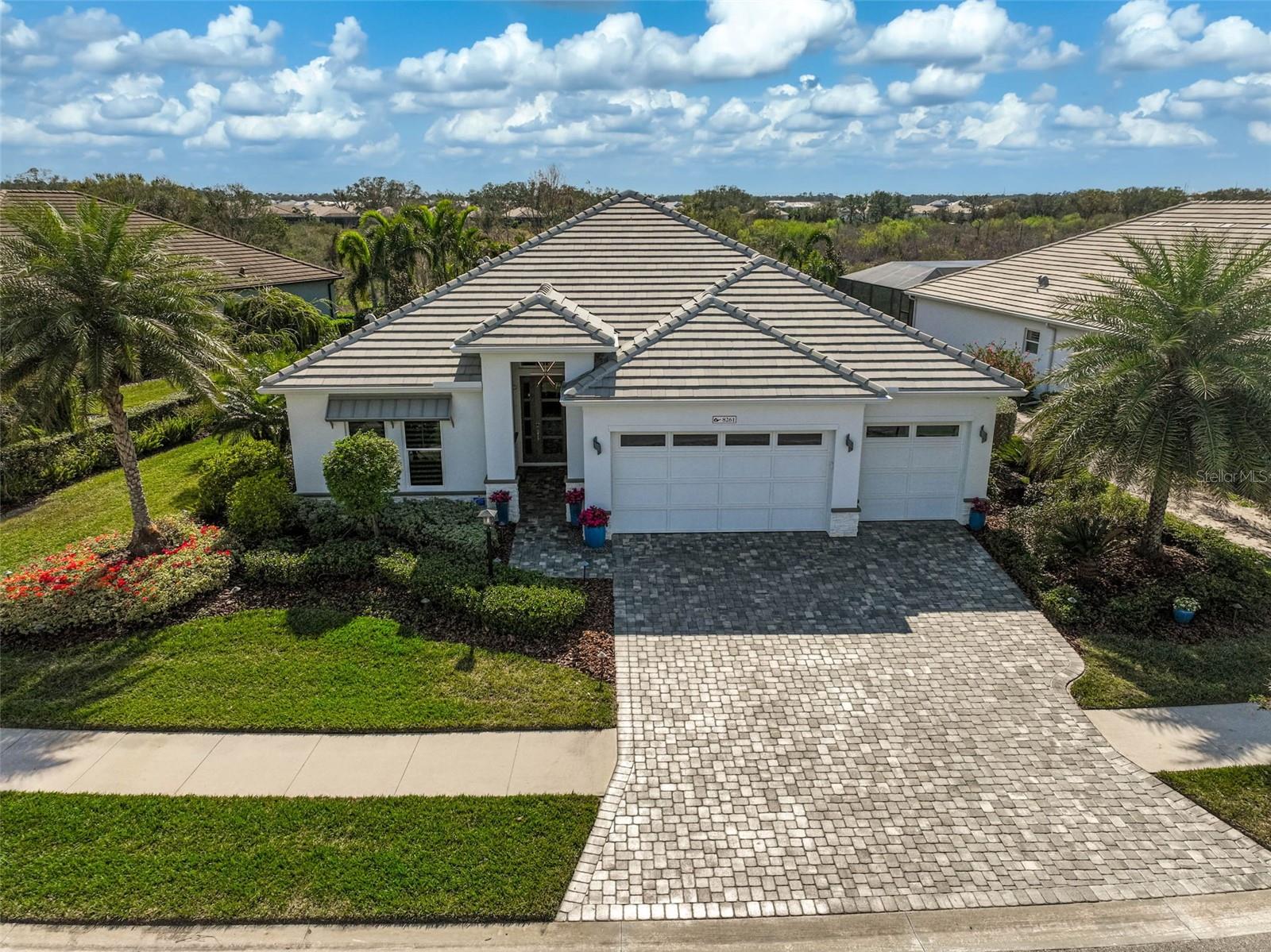 Exquisite Lakehouse Cove Estate in Waterside, Lakewood Ranch. Experience unparalleled luxury in this designer-inspired, 3-bedroom, 3-bathroom home, where high-end finishes and thoughtful upgrades redefine elegance. Nestled on one of the widest, private preserve lots, this stunning single-story residence offers 2,892 sq. ft. of impeccably designed and maintained living space. From the moment you step inside, sophisticated details captivate—the expansive, white porcelain, high-polish, tile floor; silk wallpaper; Venetian plaster built-ins and walls; and tray ceilings added to the foyer, living room, dining room, and primary bedroom (all prewired to add lighting if desired) to enhance the ambiance. A large dining area boasts a stunning, ultramodern fixture and an oversized, framed, backlit mirror mounted on custom stonework. High-end designer light fixtures and automatic Hunter Douglas motorized shades throughout seamlessly blend convenience with style; while premium, Cambria quartz countertops, a custom kitchen backsplash, extended cabinetry, GE Monogram appliances, and a bespoke breakfast nook with built-in benches and expansive picture windows elevate the gourmet kitchen. A custom Sapele mahogany door with hand-carved glass adds an elegant, artisan touch and beautifully frames the entrance to the den/office with interior lighted, custom shelving and back-mirrored quartz bar top and cabinets. Down the hallway is a bonus work station and a bright and cheery, fully equipped laundry room. Outdoors, indulge in resort-style living with an oversized saltwater, architectural pool and luxurious spa, and water features framed by an expansive, travertine deck and travertine-covered lanai columns with classic lighting. Entertain effortlessly with an outdoor kitchen that includes a built-in grill and sink, serving bar, Perlick refrigerator, granite countertops, and extra cabinets. Complete with interior cage lighting, exterior lighting and underground drainage, the professional, lush landscaping ensures privacy and beauty year-round. Beyond aesthetics, this home is designed for modern comfort, security, and peace of mind—impact windows and doors, a whole-house generator and surge protector, Safehouse security cameras (6 exterior, 1 interior), and SMART technology controlling windows, lighting, pool, and alarm systems. Additional luxuries include: custom California Closets, a spacious, walk-in shower with floor-to-ceiling tile and dual shower heads in primary suite; custom built-in closets in secondary bedrooms and all pantries; extended-height 9’ sliders for seamless indoor-outdoor flow; custom lighted mirrors and upgraded tile borders in all baths; and protective film on all windows and doors adds extra layers of UV furniture protection and heat mitigation. The 3rd full bathroom is easily accessible from both the kitchen and the lanai. The oversized garage includes epoxy flooring and custom storage cabinets, and tucked behind the third car garage door is a fully temperature-controlled, large bonus room ideal for a fitness studio, office, media room, or storage and is even equipped with a Kevlar hurricane screen. Set in the prestigious Lakehouse Cove community, residents enjoy resort-style amenities: a clubhouse, pickleball courts, fitness center, pool and spa, and a resident exclusive is a marina with a water taxi to Waterside Place. With seven lakes, nature trails, and 20 acres of pristine shoreline, this is Florida living at its finest.