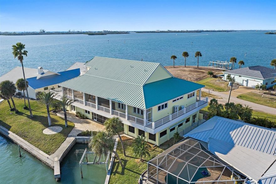 One or more photo(s) has been virtually staged. A landmark waterfront home with a story to tell, set where Lemon Bay meets the Intracoastal & the water surrounds you in every direction.

Positioned at the end of a quiet cul-de-sac on Lemon Bay, this one-of-a-kind estate situated on a third acre, offers sweeping water views, exceptional structural integrity, & a design shaped by history & purpose. With water visible from nearly every room & wraparound balconies on multiple levels, the connection to the Intracoastal Waterway, canal, & distant Gulf is constant & unforgettable.

The main living level is elevated & encircled by expansive Trex decking, blending covered & open-air spaces ideal for enjoying sunrise, sunset, & everything in between. Inside, the great room features soaring ceilings, built-in cabinetry, recessed lighting, ceiling fans, & a gas fireplace, framed by French doors opening to the surrounding balconies. The dining area flows into the kitchen, where custom cherry wood cabinetry, granite countertops, a large island with seating, pantry storage, & high-end appliances, including a Thermador gas range, create a space well suited for entertaining or everyday living. Elevator access on this level adds ease & functionality.

4 bedrooms are located on the main living floor, including 2 en-suite options. The primary suite offers French door balcony access, sweeping bay & distant Gulf views, built-in shelving, & a custom walk-in closet. The primary bath includes dual sinks, Corian countertops, & a glass-enclosed walk-in shower with dual shower heads. A second en-suite bedroom features balcony access, a custom walk-in closet, & a spa-style bath with dual sinks, glass walk-in shower, & a jetted tub overlooking the water. 2 additional bedrooms share a Jack-&-Jill bath with custom built-in closets.

The ground level is fully built out under air & functions as a private retreat with a living area, bedroom, & full bathroom with walk-in shower, ideal for guests or poolside living. This level opens directly to the covered & screened pool & spa, where paver decking & generous ceiling height create a protected resort-style setting.

At the top of the home, a bonus living space offers bird’s-eye views across Lemon Bay & surrounding waterways, with a wet bar, wine storage, refrigerator, built-in desk, attic access, & French doors to a private open wraparound balcony.

Outside, the property features a large seawall, sailboat water with no fixed bridges, & a boat lift (not warranted). The seawall allows for re-engineering to accommodate vessels up to approximately 50 to 100 feet, subject to buyer verification. Additional highlights include a small dog run with retractable awning & multiple wraparound balconies maximizing water views.

Notable improvements include a new metal roof completed in April 2024, 3 HVAC systems replaced in 2023, impact windows & doors with additional shutter protection, whole-house water filtration & softener system, security system, elevator, & solid core cherry wood interior doors & staircases. Solar panels were previously installed & removed, with infrastructure remaining for future reinstallation.

This is a rare opportunity to own a structurally impressive waterfront home where history, design, & expansive water views come together in a setting that cannot be replicated.