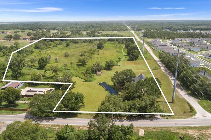 Looking to escape the noise and expense of city life for space to breathe, room to roam, and the freedom to live on your own terms? Welcome to 5820 E Johnson Ave in Haines City—a rare 17.71-acre farmstead in the heart of Central Florida that combines self-sustaining country living with modern comfort and unbeatable convenience. Opportunities like this are exceptionally hard to find—true acreage just 35 minutes from Disney World and Orlando’s attractions. Set behind a private gated entry, the land is peaceful and picturesque, featuring a gently flowing creek, multiple access points, cross-fenced pastures for horses or livestock, a large chicken coop, and a hog pen—all ready for those seeking an independent lifestyle. At its center stands a beautifully renovated modern farmhouse offering over 3,000 square feet of living space and more than 4,000 square feet under roof. Inside, high ceilings, soft-hued plank flooring, energy-efficient windows, and a cozy wood-burning fireplace create an inviting atmosphere. The showpiece kitchen is built for farm-to-table living, with quartz countertops, stainless steel appliances, ample cabinetry, and a wrap-around breakfast nook perfect for family gatherings. The split-bedroom layout provides privacy, with the primary suite offering screened porch access, a large walk-in closet, and a well-appointed en-suite bath. Two additional bedrooms and a full bath are tucked away on the opposite side, along with a formal dining room, an office or fourth bedroom, and a screened porch overlooking the tranquil acreage. Upstairs features a spacious bonus room ideal for a playroom, media space, or man cave, plus a separate air-conditioned storage room for valuables or seasonal items. An oversized three-car garage and multiple sheds provide abundant room for equipment, hobbies, or expanding your agricultural vision. Though the property feels worlds away, you’re just 3 minutes from Publix, 15 minutes from Lowe’s, 30 minutes from Posner Park, and 45 minutes from Orlando International Airport. Located in the thriving community of Haines City—known as the “Heart of Florida”—this one-of-a-kind property delivers the best of both worlds: rural tranquility, modern amenities, and proximity to world-class golf, dining, and entertainment. Whether you dream of a working ranch, private retreat, or a place to simply live freely on your own land, 5820 E Johnson Ave offers a truly rare opportunity to own acreage this close to Disney.