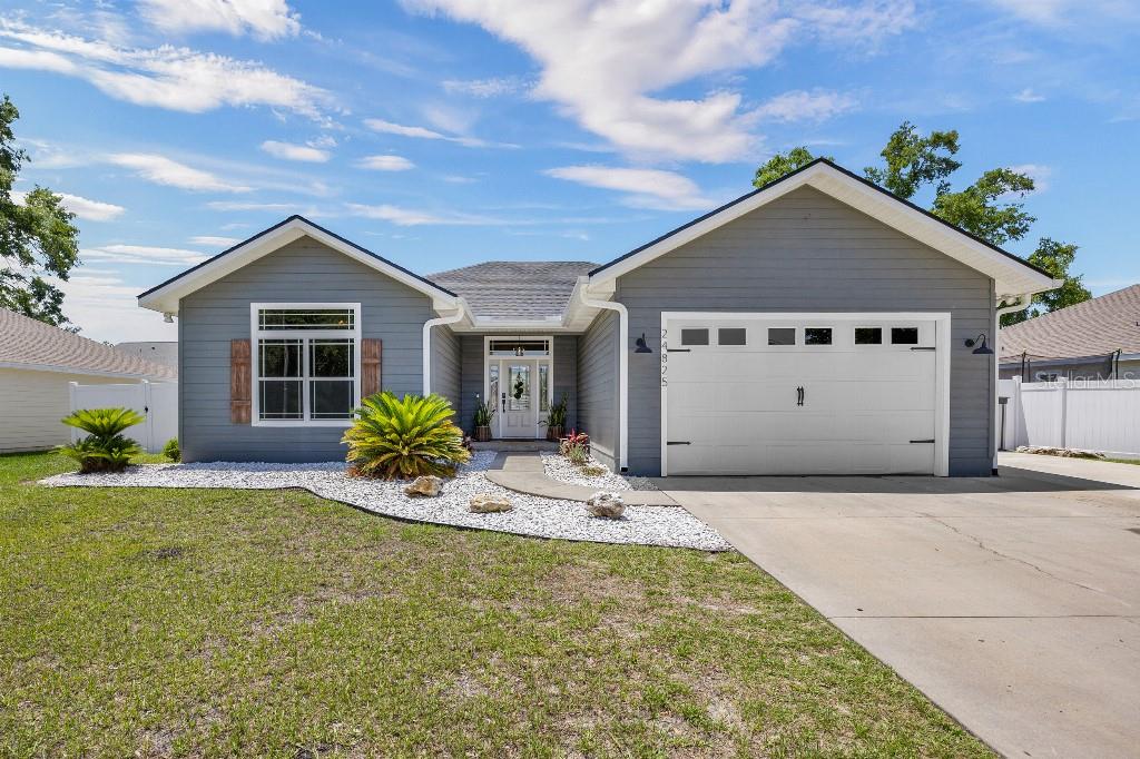 This beautifully updated 3-bedroom, 2-bathroom home is move-in ready and full of modern touches! From the moment you walk in, it just feels like home. Inside, you'll love the 9-foot ceilings throughout, with soaring vaulted ceilings in the living room and primary bedroom, creating a bright and open feel. Recent upgrades include a brand NEW ROOF (2025), 3.5-ton HVAC system (2022), garage enclosure perfect for a second living room or man cave, new flooring throughout, a spacious pantry, and a full exterior repaint in 2021. The kitchen is a standout with its fresh backsplash, ample storage, window above the sink overlooking the adorable back porch, and a cozy island with extra seating. The new lighting and plumbing fixtures give the home a fresh, stylish feel. Outdoor living is a breeze with an extended driveway, concrete side patio, and rear patio—perfect for gatherings and summer BBQs. The home is also pre-wired with a 50-amp generator hookup for peace of mind. Located in a walkable, bike-friendly neighborhood just minutes from top-rated schools, local springs and rivers, downtown High Springs, I-75, colleges, and hospitals, this home offers the perfect blend of comfort, style, and convenience.