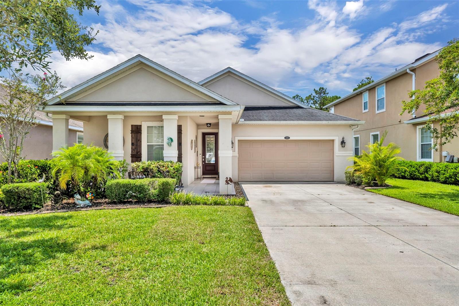Live the life others dream about! Coastal comfort and everyday elegance come together in this exceptional 3-bedroom, 2-bath home located in the highly sought-after Grande Champion community at LPGA International. Built in 2012 and meticulously maintained, this 1,761 square foot home features tile flooring in the main living areas and a thoughtfully designed split-bedroom layout that offers both privacy and function. A welcoming front porch sets the tone for the charm you’ll find throughout. Inside, the foyer makes a warm first impression. To the left, a private guest wing includes two spacious bedrooms, a full bath, and a laundry room with built-in cabinets that help keep everything organized. At the heart of the home, the open-concept great room flows into the kitchen and dining area, making it ideal for entertaining or everyday living. The kitchen is both stylish and functional, featuring stainless steel appliances, a pantry, tiled backsplash, and a center island with seating, a sink, and decorative tile accents. Sliding glass doors off the living area open to a back patio, offering an easy transition to outdoor living. The primary suite is privately located and serves as a relaxing retreat, complete with dual sinks, a soaking tub, a separate shower, and two walk-in closets—one in the bedroom and another in the ensuite bath. The fully fenced backyard is beautifully landscaped for added privacy, while paver walkways on both sides of the home add curb appeal and convenience. Additional features include a two-car garage and a low quarterly HOA fee that provides access to the community pool and cabana. Conveniently located just minutes from I-4, I-95, shopping, dining, and only eight miles from the world-famous Daytona Beach, this move-in ready home offers the ideal blend of comfort, style, and location. Don’t miss your chance to tour this beautiful home—schedule your private showing today and see why it stands out from the rest!