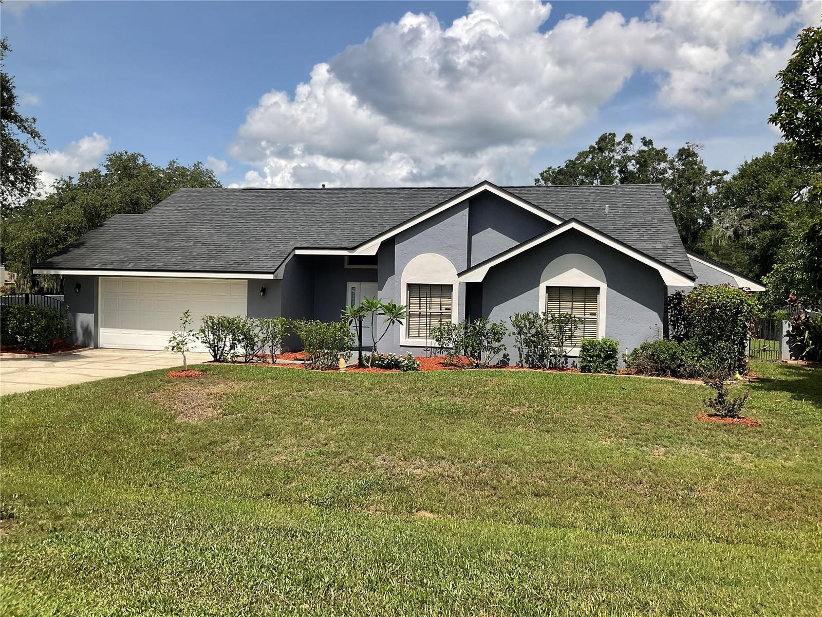 This 3 bedroom 2 bath home is located in an established neighborhood close to the Polk parkway for easy access to Orlando or Tampa. The Kitchen is equipped with stainless steel appliances, wood cabinets, granite counter tops, breakfast bar. There is a fire place and a wet bar in the large living room with beautiful tile & wood flooring throughout the home. The back porch is screened and the entire backyard is beautifully landscaped with mature landscaping, various trees and surrounded with a brick wall. There is also a detached workshop that is completely finished with tile floors and air conditioning. The home features a gas tankless hot water heater and smart lock on the doors.