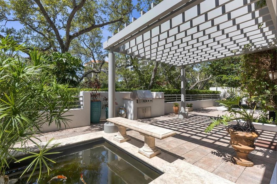 Welcome to a truly exceptional offering in downtown Sarasota – an exclusive 3rd floor condo in the Savoy on Palm, an intimate building of only 24 units. Rarely available, this distinguished building and unique residence truly stands out amongst the crowd, offering security of a condo with the feelings of a house and yard. With easy access on the main level, this condo features a sprawling terrace over 3400 square feet that is a haven for dog owners and outdoor enthusiasts alike. Sliding and french doors lead you to the terrace from most rooms of the home. This expansive outdoor space is a private oasis, complete with a koi pond accompanied by a soothing waterfall, a gas grilling area, and plenty of seating space surrounded by the lush greenery of flowering trees. The interior of this condo seamlessly pairs elegance with space and functionality. Beautiful crown moldings, elegant window treatments, gas fireplace, and travertine marble floors adorn the living spaces, creating a warm and inviting atmosphere. With 3 bedrooms plus a den, 3.5 bathrooms, and approximately 3200 square feet, there is no shortage of space for comfortable living. The kitchen features plenty of cabinet space, Sub Zero, Dacor, and Bosch stainless appliances, wine refrigerator, a connection for gas cooktop is in place, a center island with sitting area, and a direct access to the terrace. The owner’s suite features custom walk-in closets, tray ceilings, and an ensuite bath, including double vanities, a marble walk-in shower, and large jetted tub to relax in. The den, currently utilized as a dining room, adds versatility to the layout, allowing you to personally tailor the space to your preferences. There is also a large laundry room with utility sink and plenty of storage. The 2 air conditioning units were replaced 3 years ago. Additionally, the property boasts the luxury of a private oversized 2-car garage and a storage area, providing secure parking and extra space for your belongings. Offering same-floor access, the Savoy on Palm features an array of amenities. You will find the lounge, complete with a catering kitchen, a state-of-the-art fitness center and massage room, and should guests wish to stay the night, a guest suite is readily available for their comfort. Enjoy the resort-style heated pool and spa, summer kitchen, convenience of a concierge, and a rooftop terrace providing panoramic views of the city skyline and stunning Sarasota Bay sunsets. This condo presents an unparalleled opportunity to experience the best of downtown Sarasota living. Walkable to the bayfront, many shops and restaurants, as well as the theater district, and a quick drive to St. Armands Circle and the white sand beaches, you have all Sarasota has to offer right at your fingertips. Rarely does a residence of this caliber become available – seize the chance to make it yours and indulge in the ultimate urban retreat.