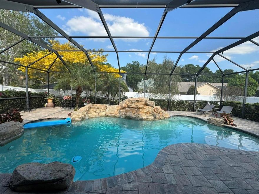 PRICE REDUCED!!!****ATTENTION BUYERS!!!!****Our preferred Lender is offering up to 1% closing cost assistance, a free appraisal up to $900 and rates from 5.8% to 5.99% for well qualified buyers.  THIS BEAUTIFUL POOL HOME is conveniently located near "A" Rated Bloomingdale High School and features 3 bedrooms, 3 full bathrooms, a den, dining room, great room, kitchen combination with separate eating area and seating at the island.  The two secondary bedrooms have been updated with hurricane windows; a full bathroom is on one side of the home and the primary bedroom and sitting area with cozy stone fireplace and custom bookshelves on the other.  The master ensuite features double sinks, a stand-up shower, sunken tub, linen closet and private water closet.  A generously sized closet completes this spa like space. The kitchen, great room and primary bedroom all open up to a gorgeous pool area with rock formation water feature and private fenced in backyard.  The backyard green area has plenty of space for a playset, outdoor toys or room for pets to safely roam.  There is also a full bathroom conveniently located off of the enclosed patio and pool area. This one owner home has been lovingly cared for with new paint, a new AC unit in 2020. new porcelain tile flooring throughout and carpeting in the third bedroom. The full hall bathroom was completely renovated in 2022. This home boasts upgrades such as beautiful crown molding throughout, kitchen tile backsplash with undercabinet, lighting, gorgeous granite countertops, plantation shutters, wide baseboards, updated kitchen island with ample storage, new dishwasher, front hurricane windows and finished knee walls. The 3-car garage features organizational systems perfect for keeping all of your outdoor gear This home has amazing curb appeal with mature and very lush landscaping including palm trees in the pool area and backyard!