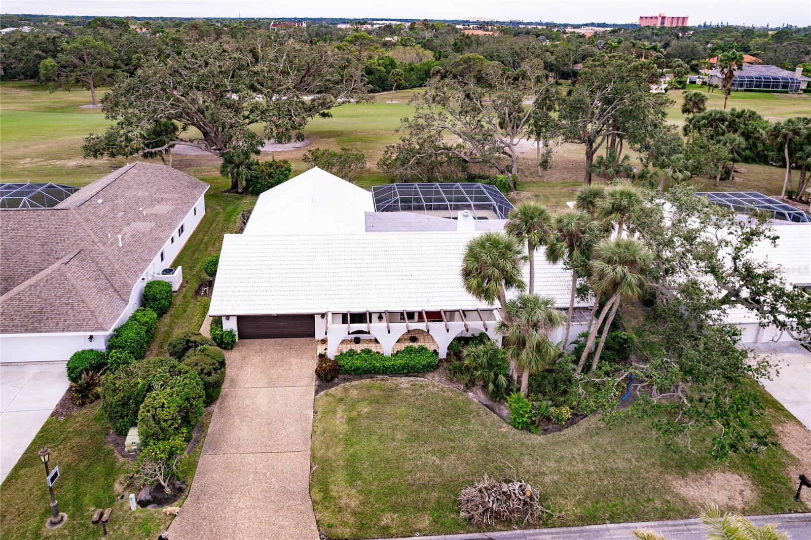 Gorgeous and expansive TPC Players Golf Course views framed by oaks provide the setting for this elegant home in one of the most established gated community of The County Club of Sarasota. Step inside to the warm living room with a woodburning fireplace and views out to the heated pool and golf course. The home features beautiful oak flooring, an updated central kitchen with granite tops, custom light maple cabinetry, and stainless appliances. The roof was replaced in 2020, 2024 water heater, new pool heat pump, and the home was re-piped. All four bathrooms were mostly or totally updated. There is a rear bedroom with an added ensuite bathroom that is perfect for an in-law suite. This exceptional home features ample room to entertain or relax with oversized rooms throughout creating an air of grandeur making this residence perfect for those who appreciate a stately living environment. There is a separate dining room, living room with vaulted ceiling, loads of storage, and a huge laundry room. Step out to the 50'x40' covered and screened patio and pool area and enjoy nature with views out to the TPC Prestancia golf course and relax in the heated swimming pool or hot tub. The Country Club of Sarasota is a 24-hour gated and staffed community and contains The Sarasota Sports Club within its gates. It has 20 Har-Tru tennis courts, 3,600s.f. fitness center, junior Olympic heated pool, meeting rooms, and more. The community is only 1 mile from the to-be-built Sarasota Square retail & restaurants, and 4.5 miles to both I-75 and to Siesta Key. Don't miss this beautiful home with plenty of space and many updates.